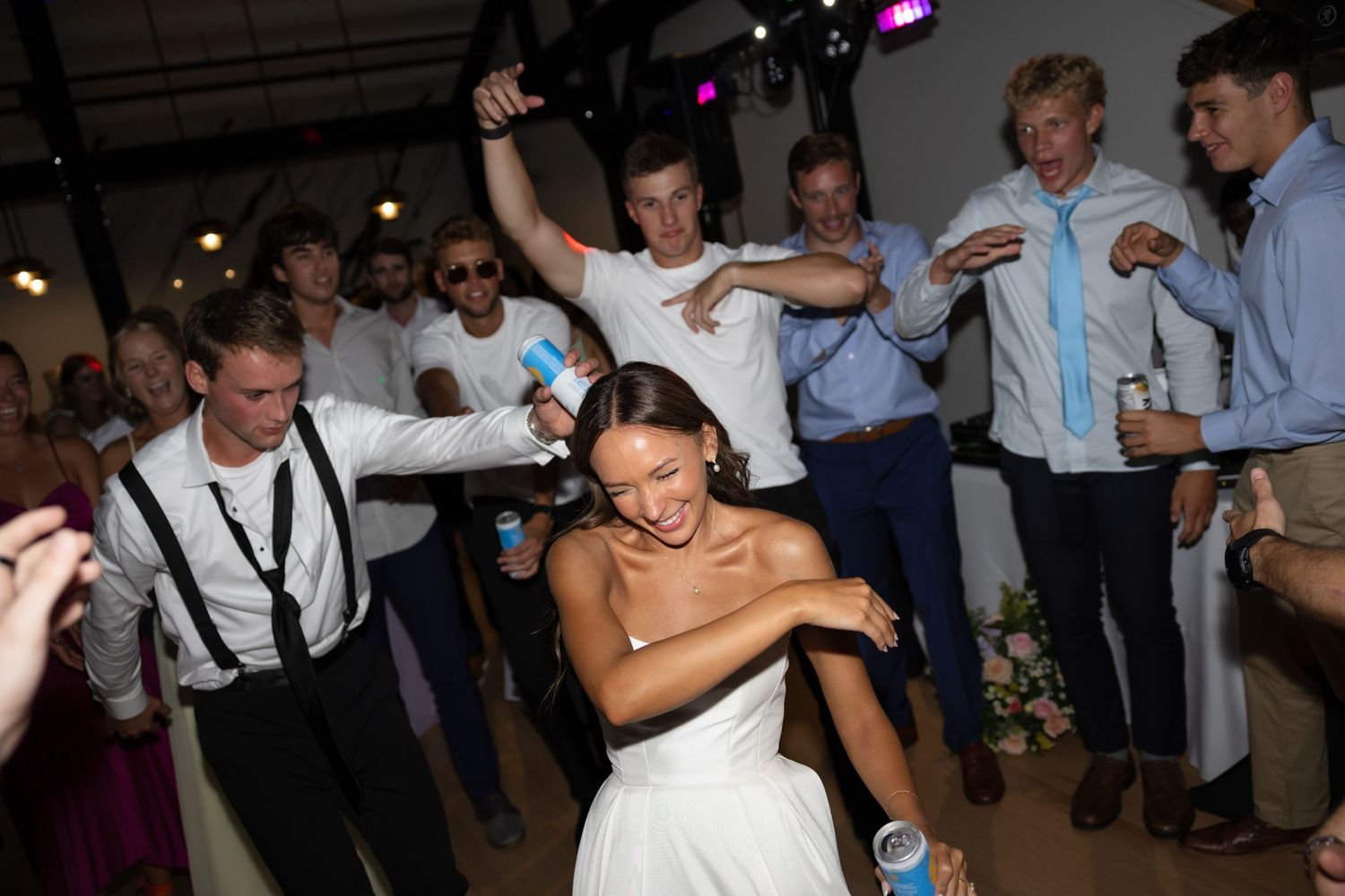 Party guests dancing and having fun on a dimly lit dance floor.
