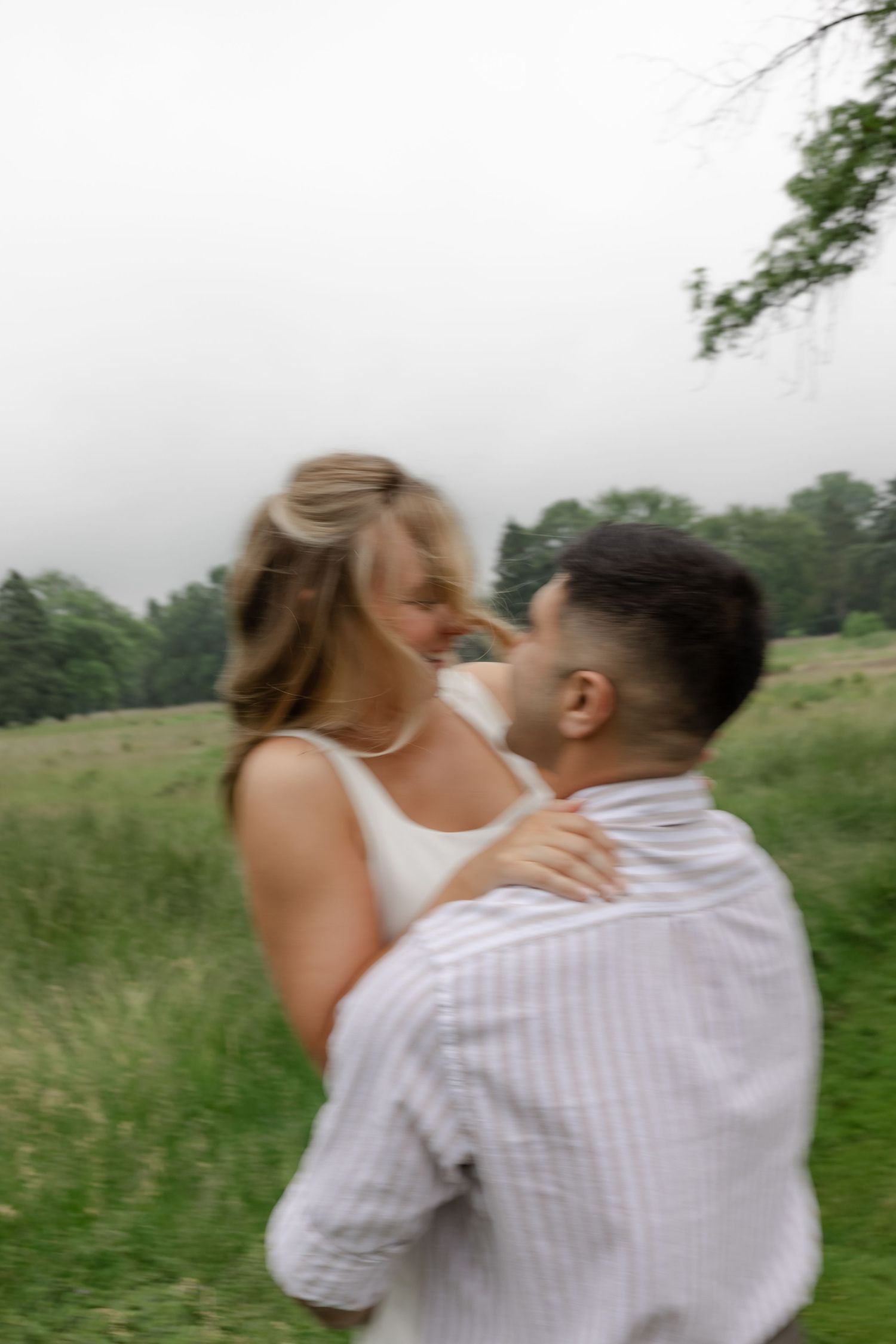 A couple embracing and dancing in a green summer meadow.