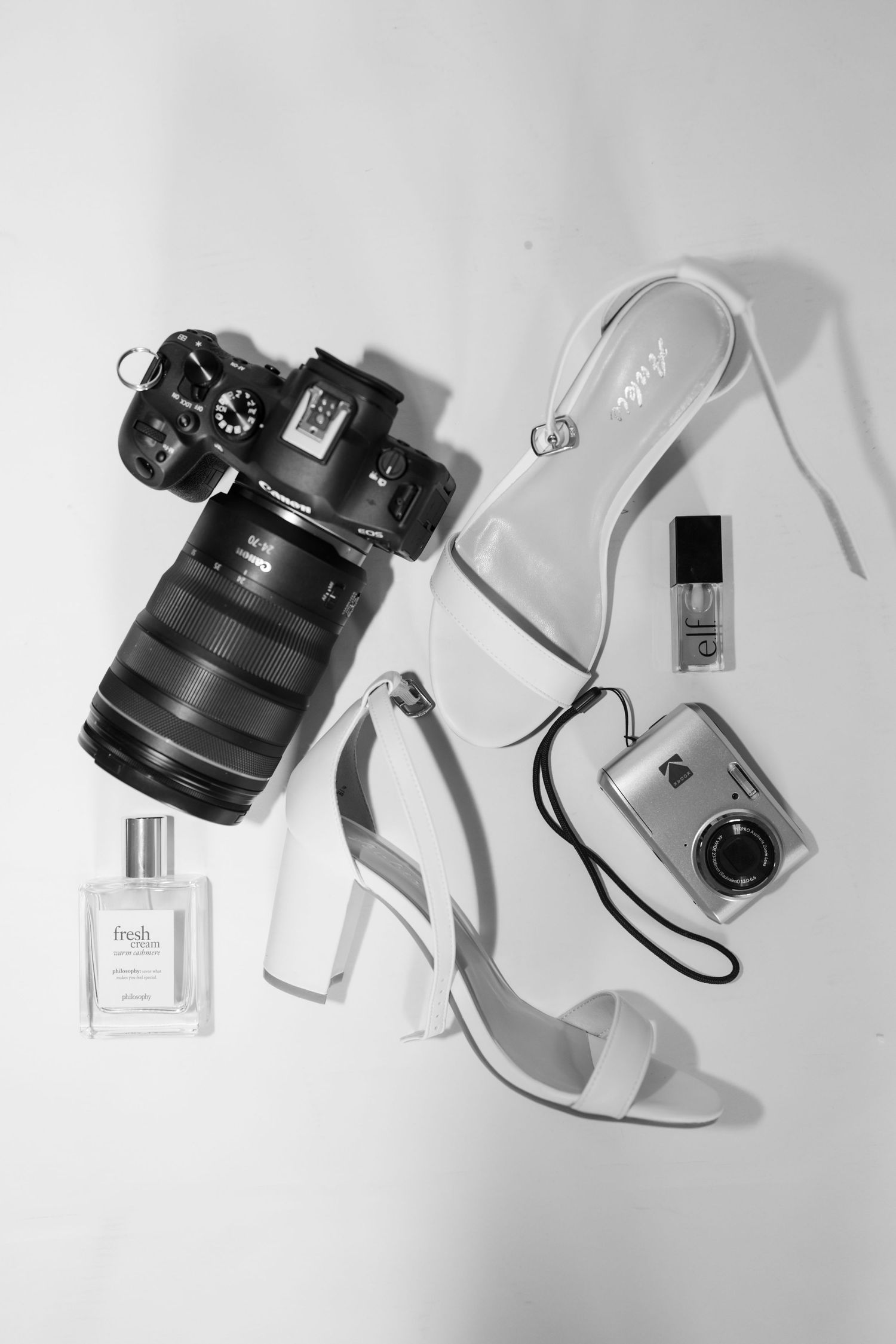 Flatlay of photography equipment and accessories on white background.