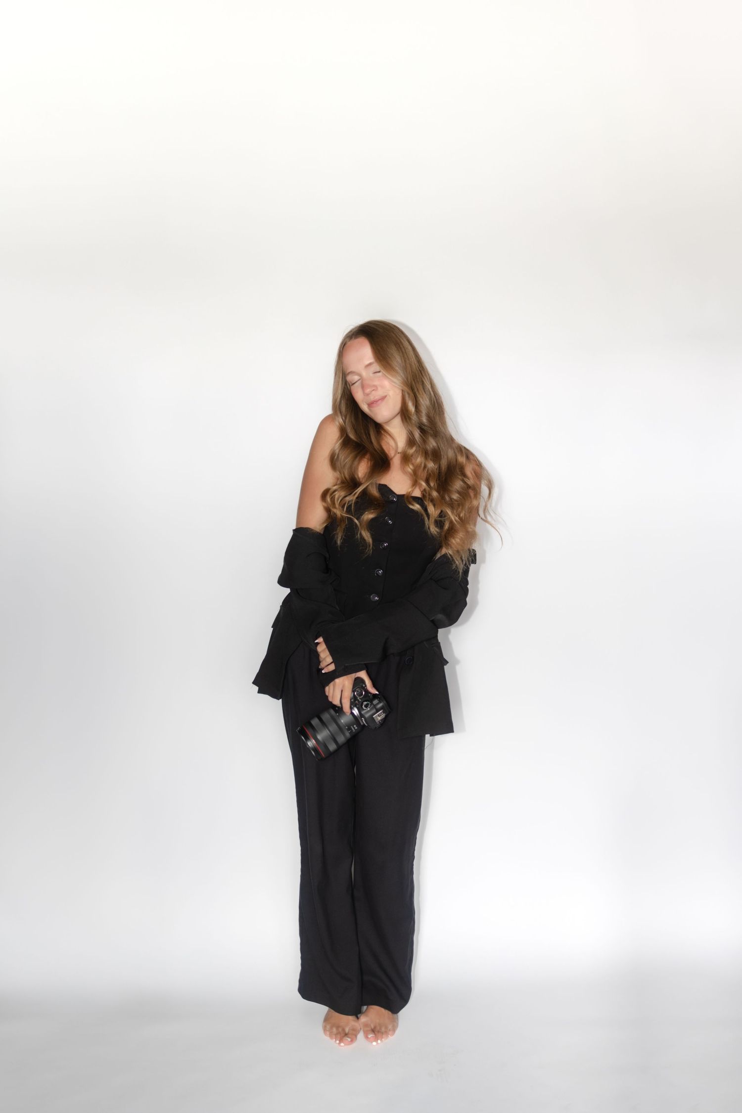 A series of expressive poses in a flowing black outfit against a white studio backdrop.