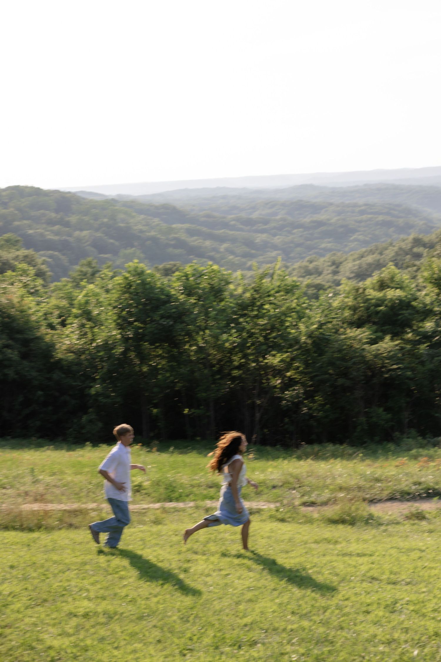 A sequence showing playful movement and dance in a sweeping hillside meadow.