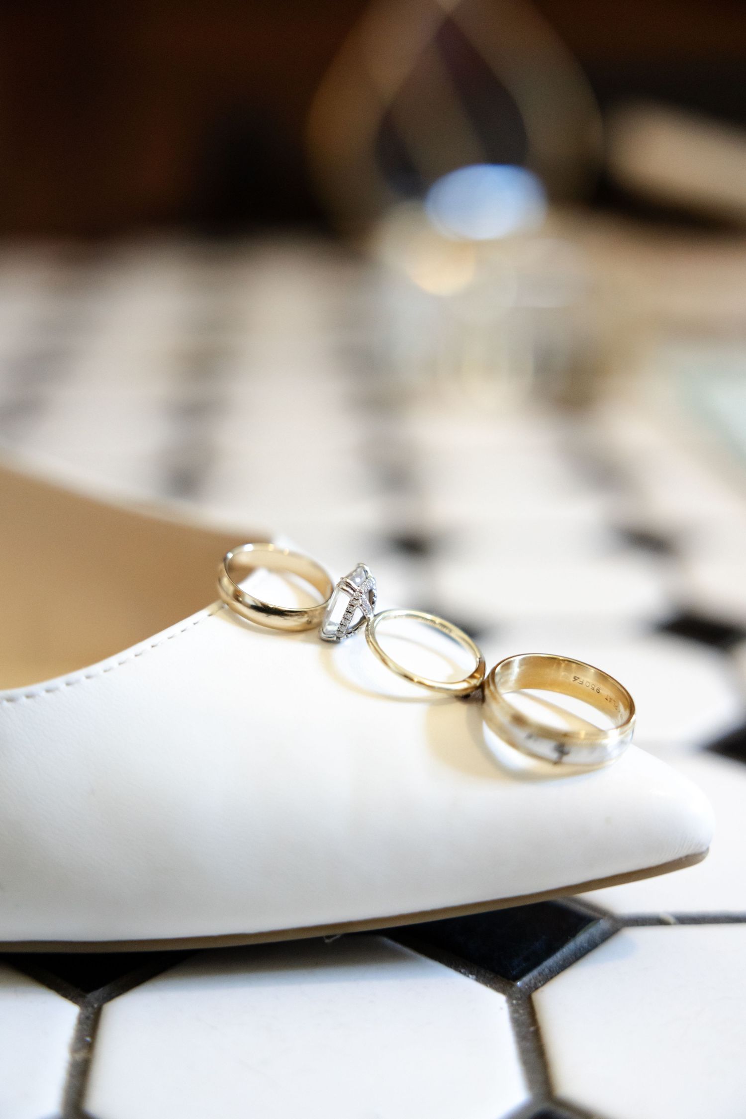 Close-up of wedding rings with selective focus on white surface.