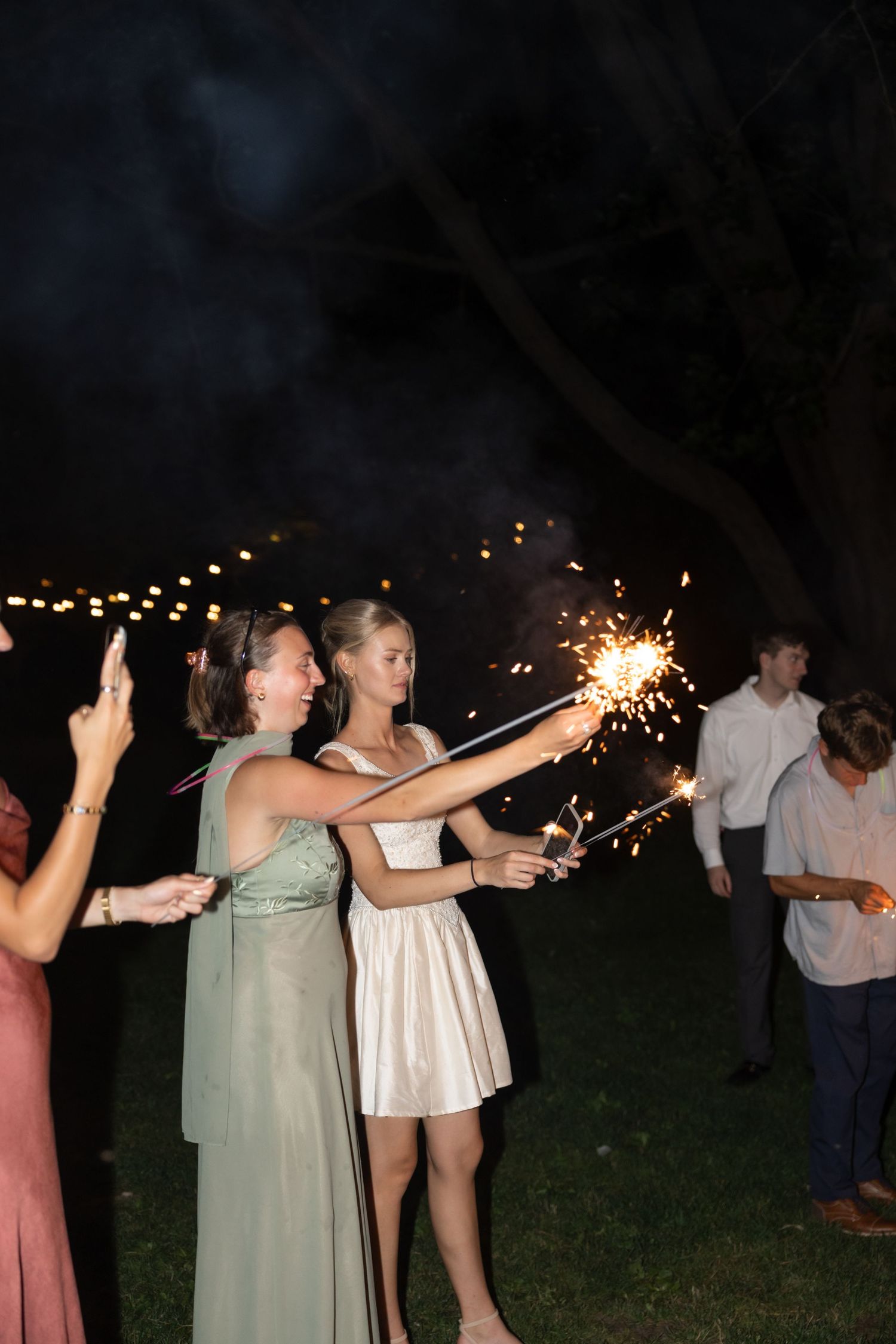 A line of sparkler-holding guests create a magical moment at an outdoor nighttime party.