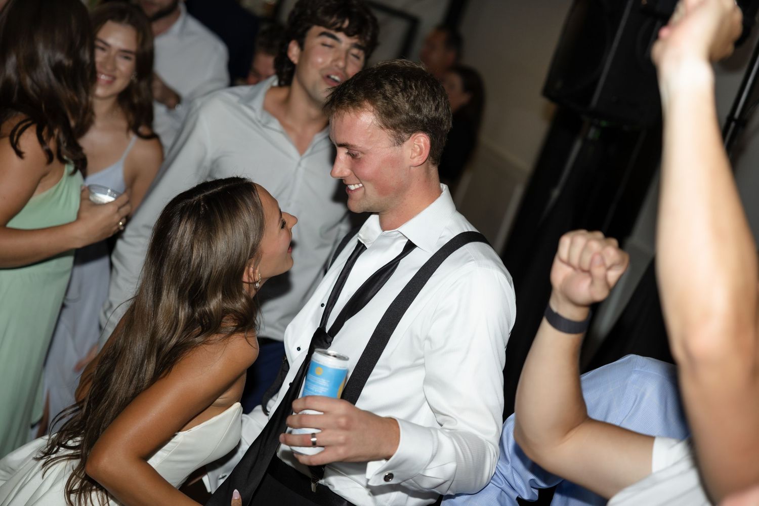 Wedding reception guests dancing and mingling on the dance floor.