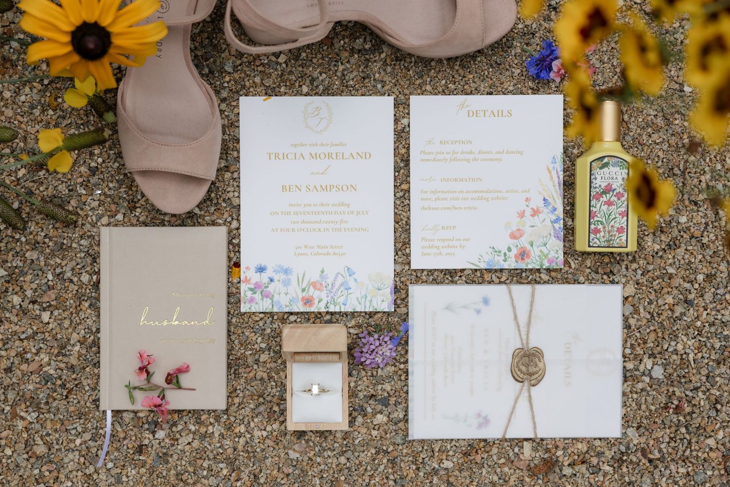 Wedding invitation suite with sunflowers and delicate floral designs on textured surface.