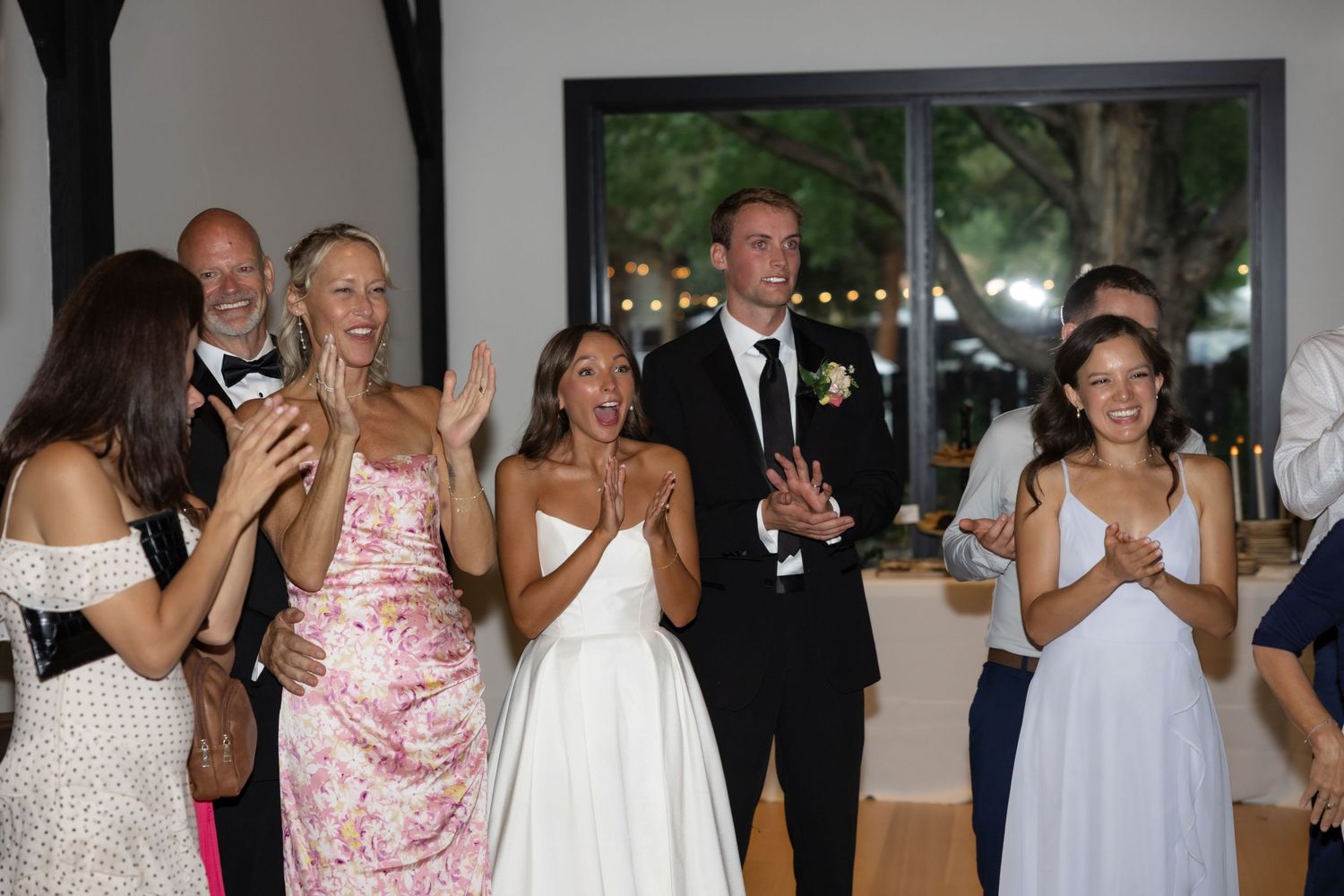 Wedding guests applaud and cheer during reception celebration.