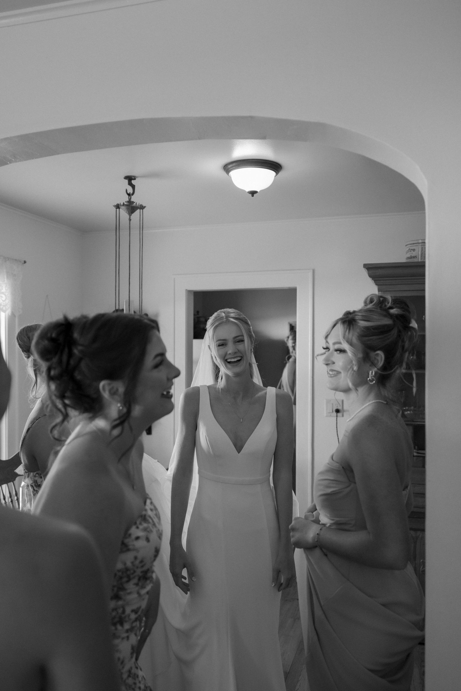 Joyful pre-wedding moments captured in black and white as wedding party prepares.