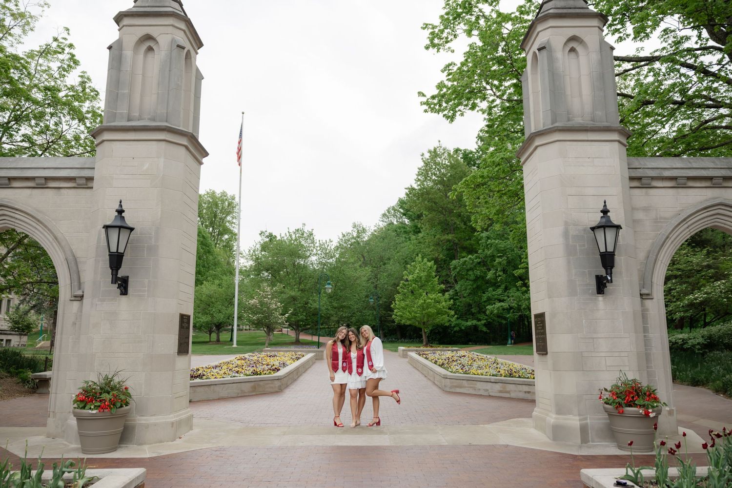 Stone archways and lampposts frame a walkway on a college campus.