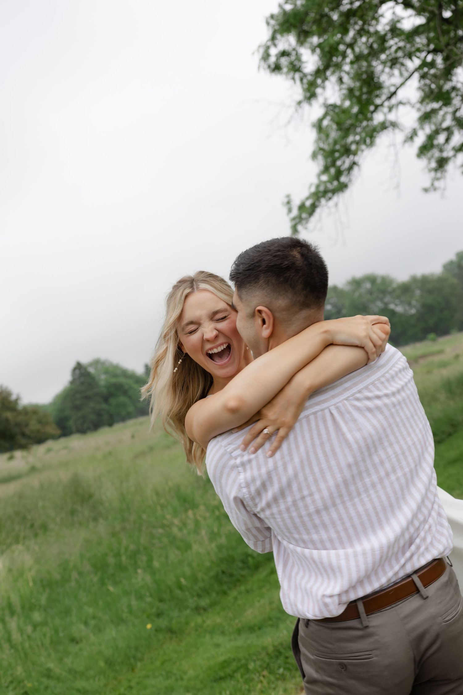 A joyful moment captured between a couple in a grassy field.