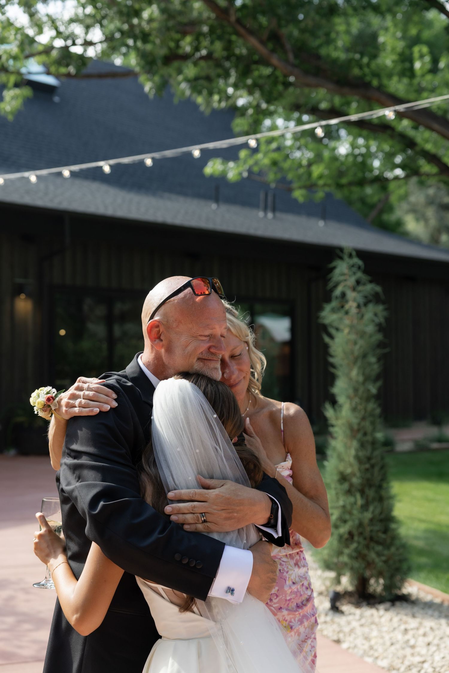 A romantic first kiss moment between newlyweds at an outdoor wedding ceremony.