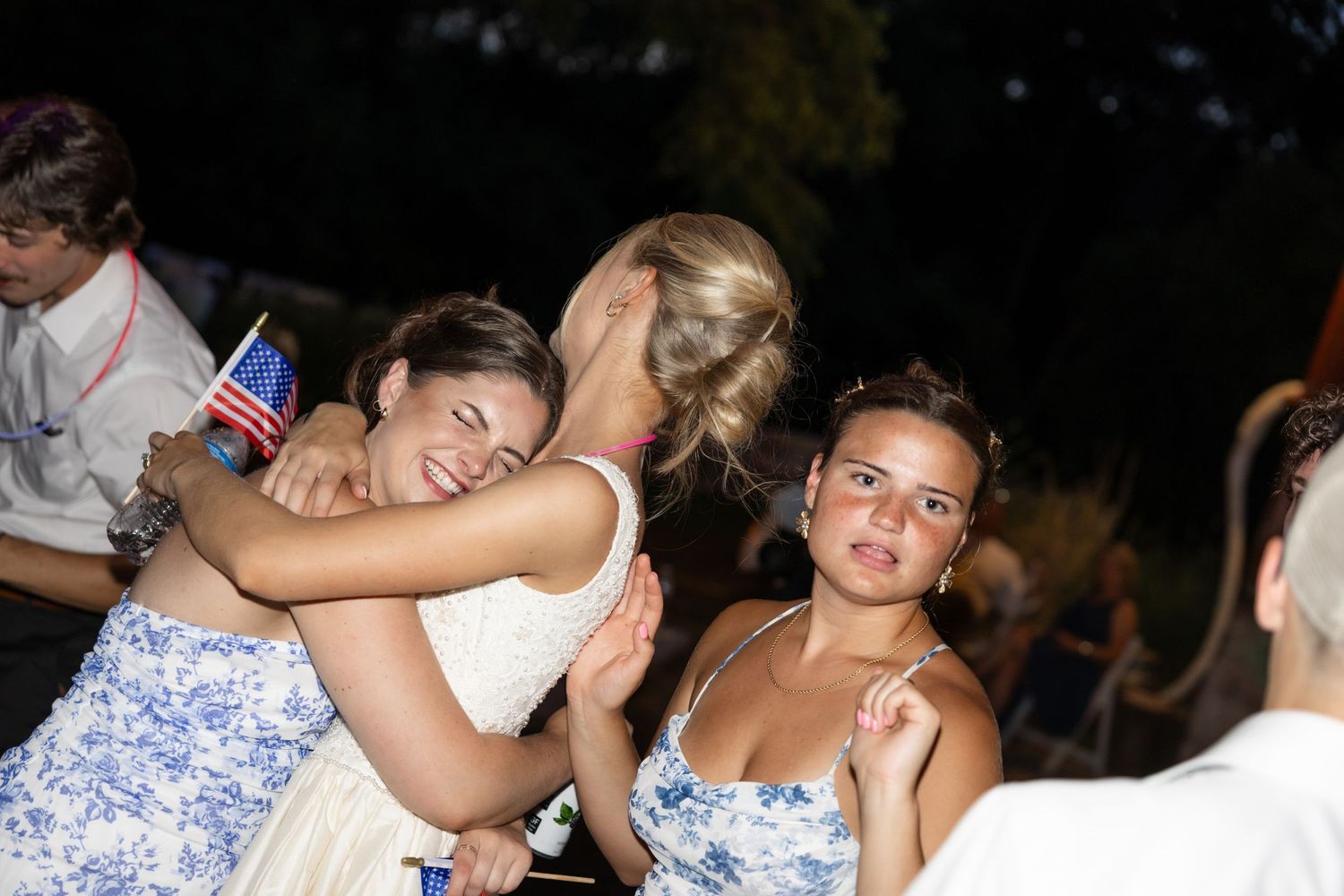 Crowd dancing and celebrating at outdoor nighttime event.
