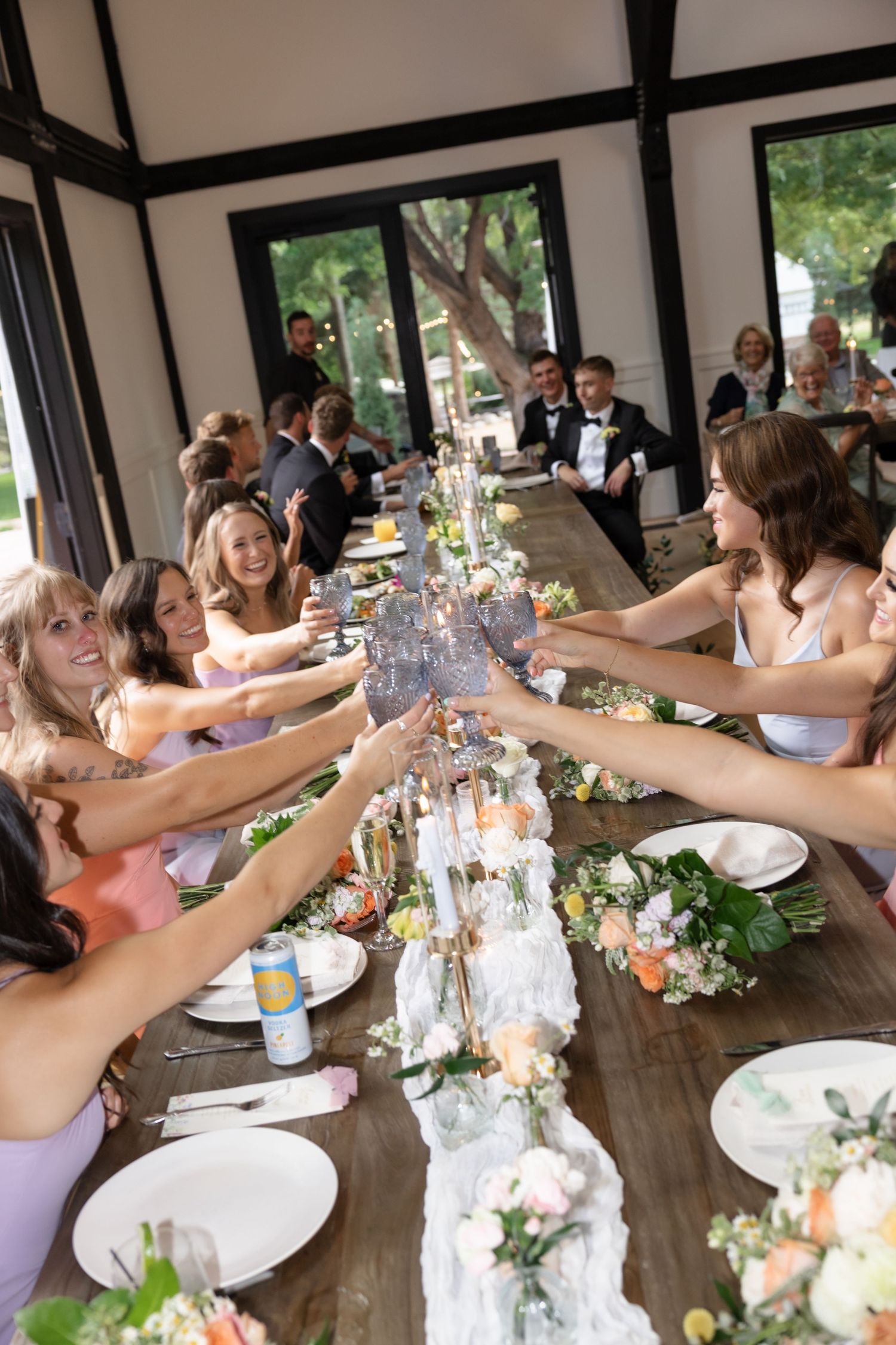 Wedding reception guests raising champagne glasses in a celebratory toast.