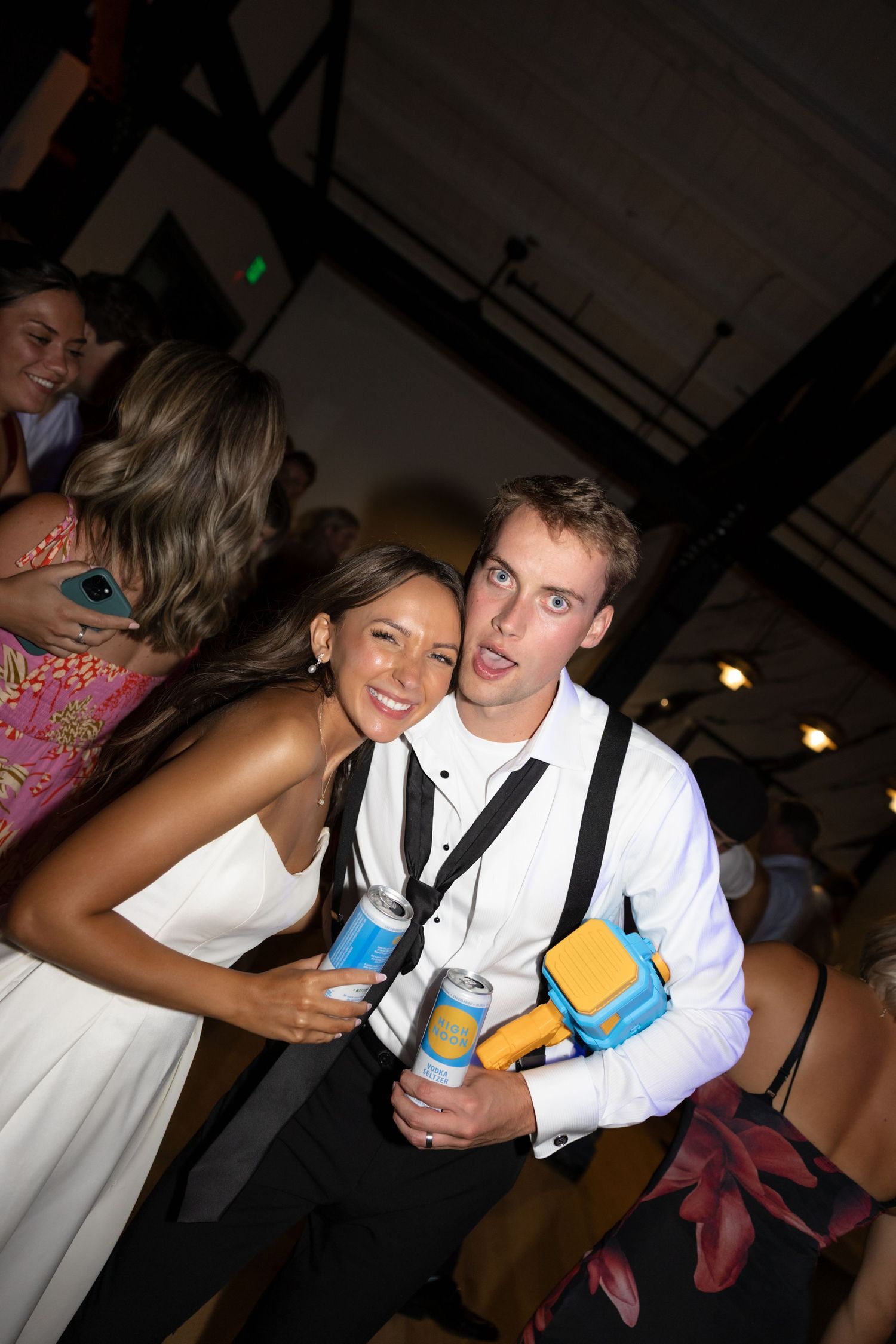 Reception guests having fun with drinks and dancing at a wedding celebration.