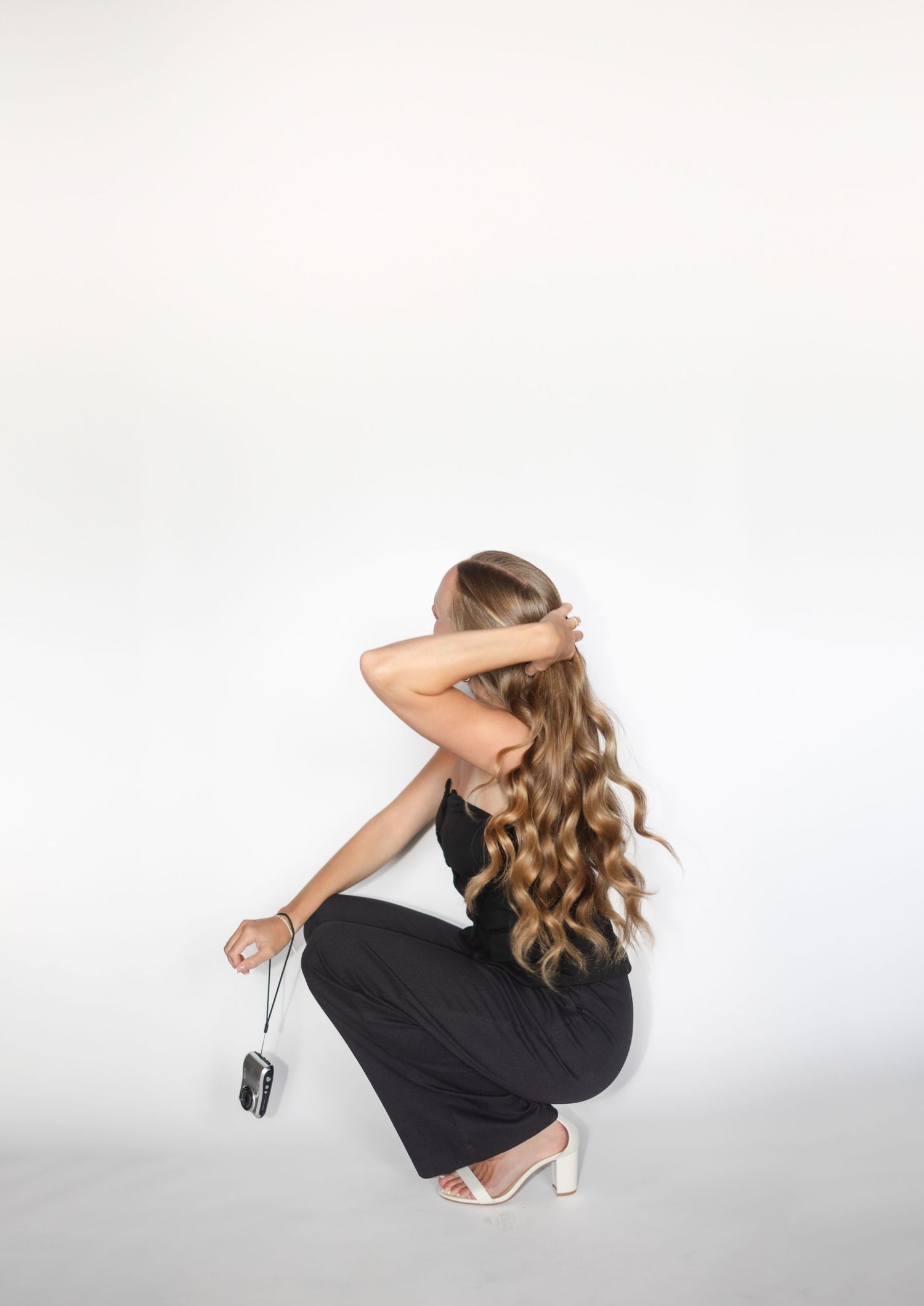 Artistic portrait series against white backdrop showing dynamic movement in black attire.