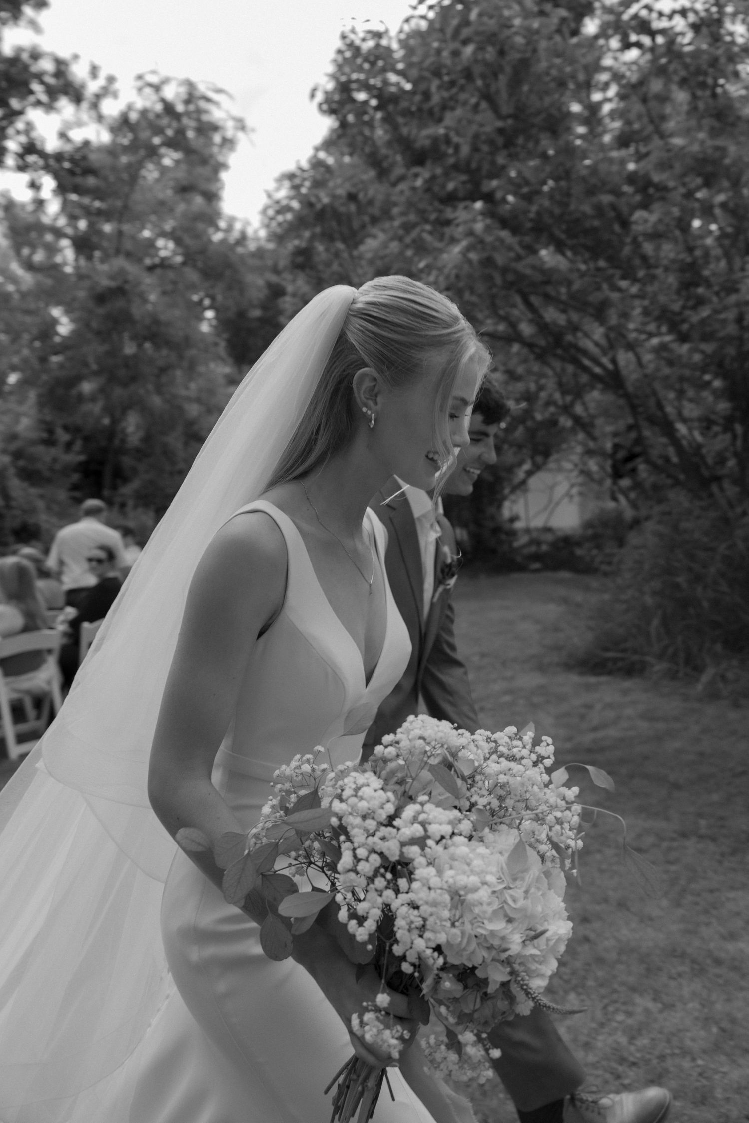 Close-up profile views of bride with white bouquet in black and white.