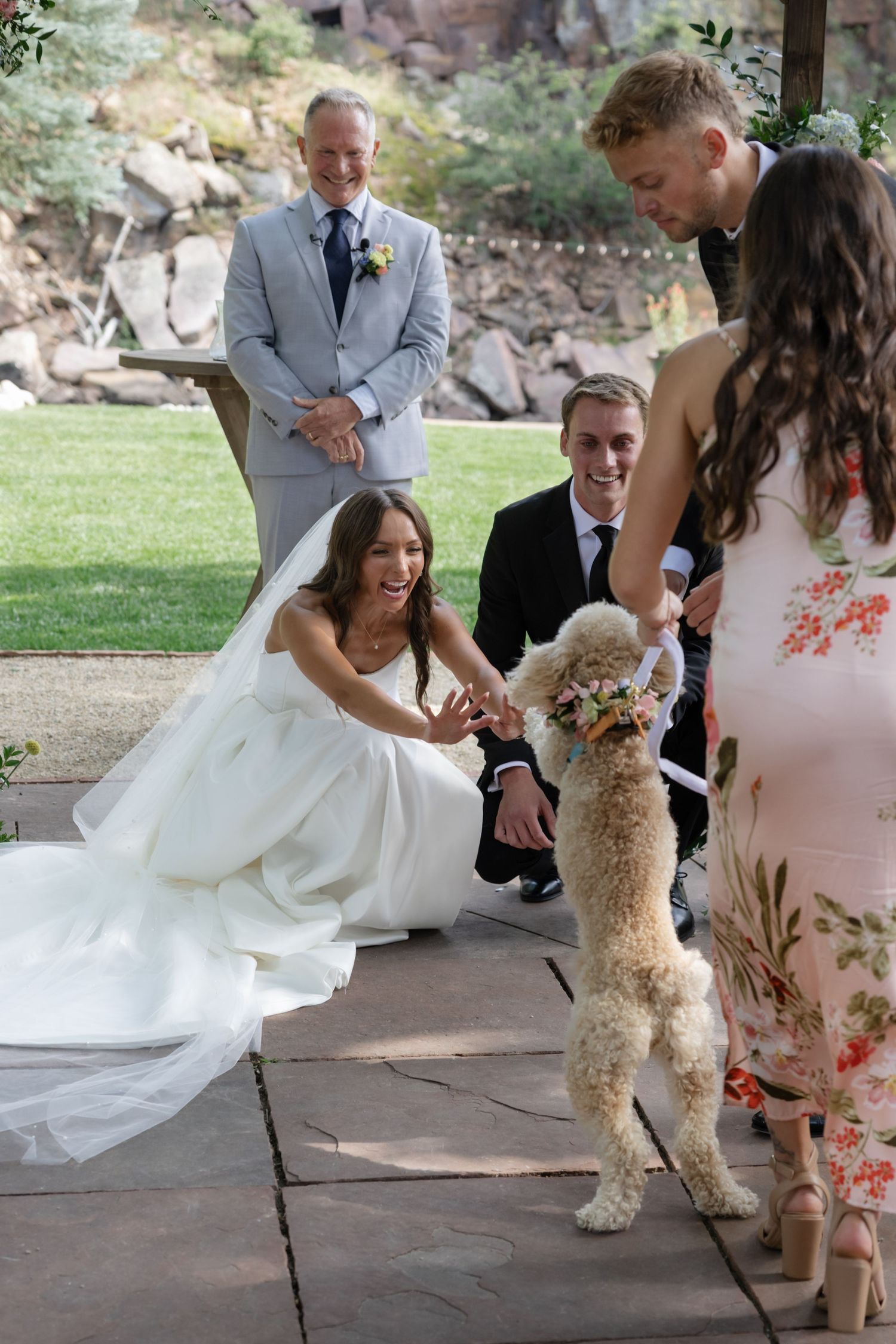 Playful moment with a fluffy white dog during wedding ceremony celebrations.