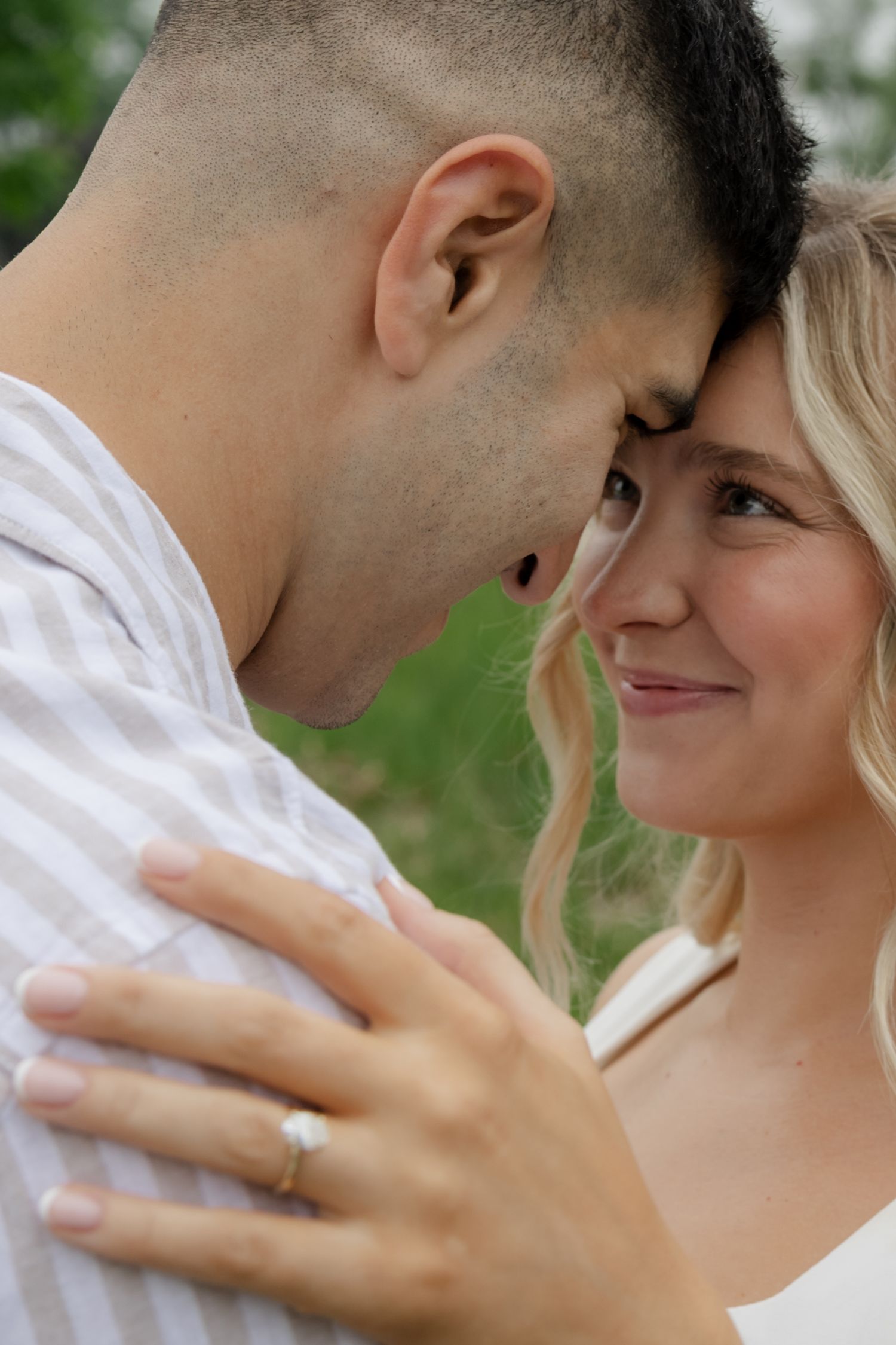 A tender moment between a couple during an outdoor photoshoot.