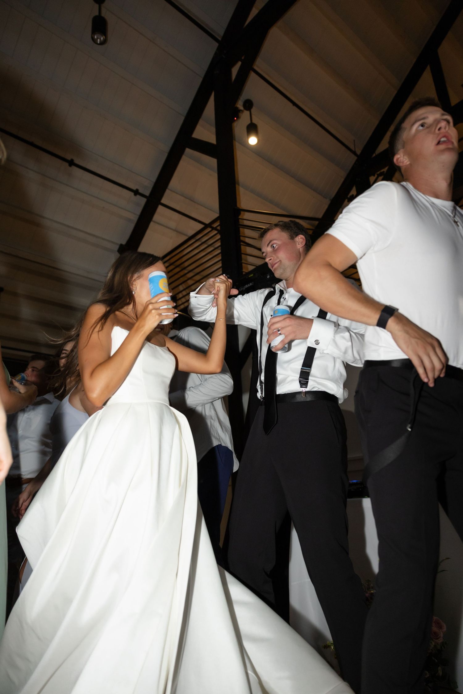 Couples dancing and twirling in formal attire at a wedding celebration.