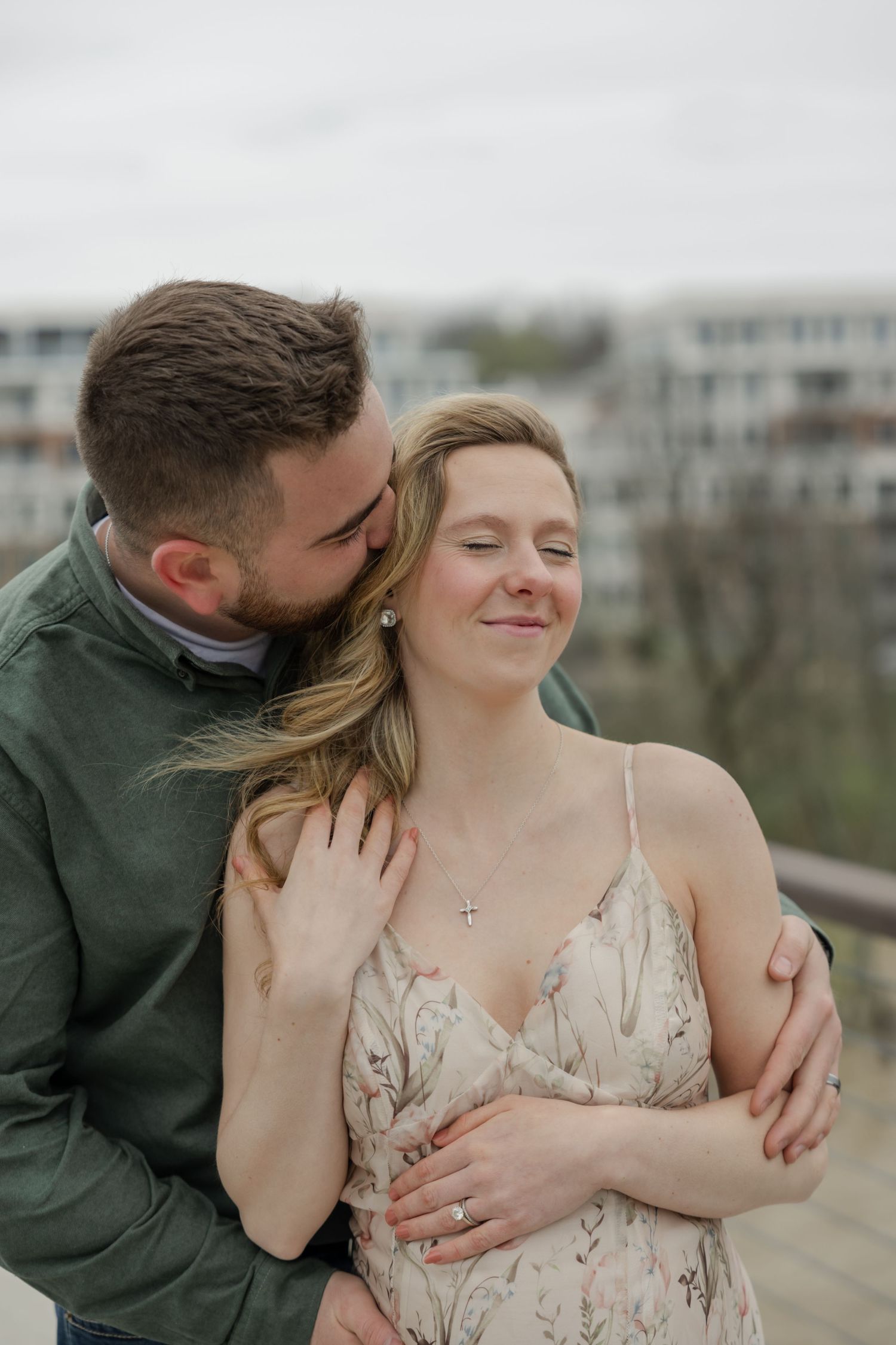 Intimate embrace between couple during outdoor maternity photography session.