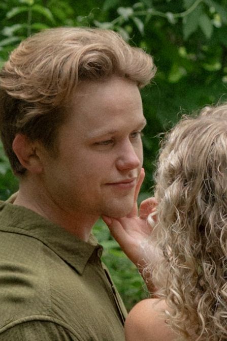 Close up of tender moment between two people in a natural outdoor setting.