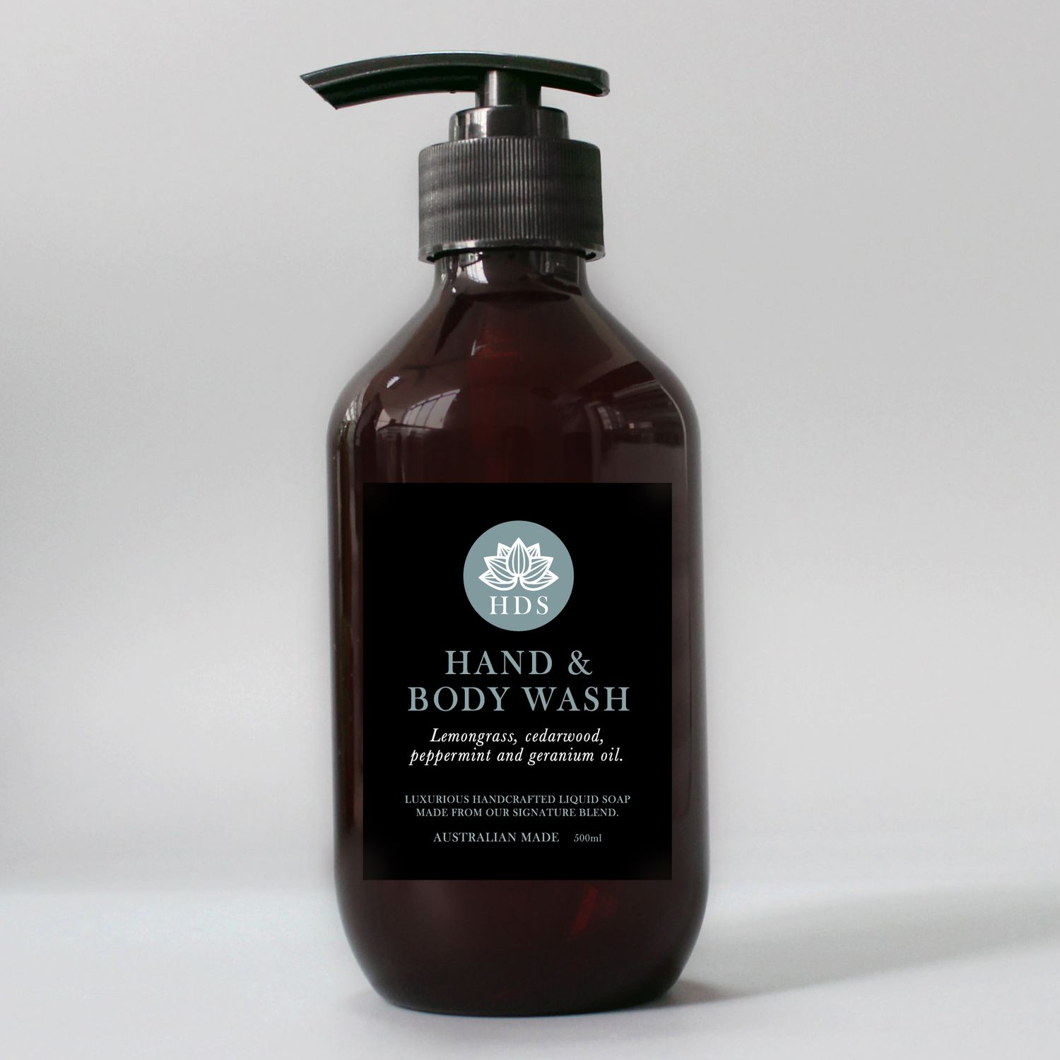 Dark amber glass bottles of hand and body wash products displayed on white background.