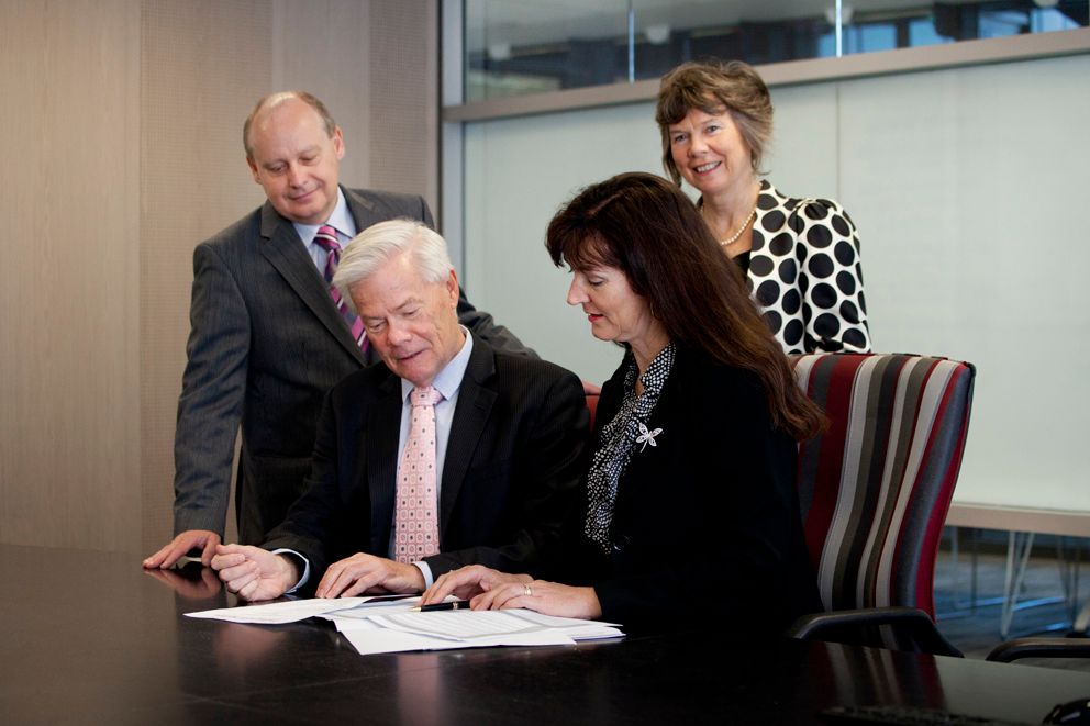 Brisbane business photography illustrating business meeting participants reviewing documents together at conference table.