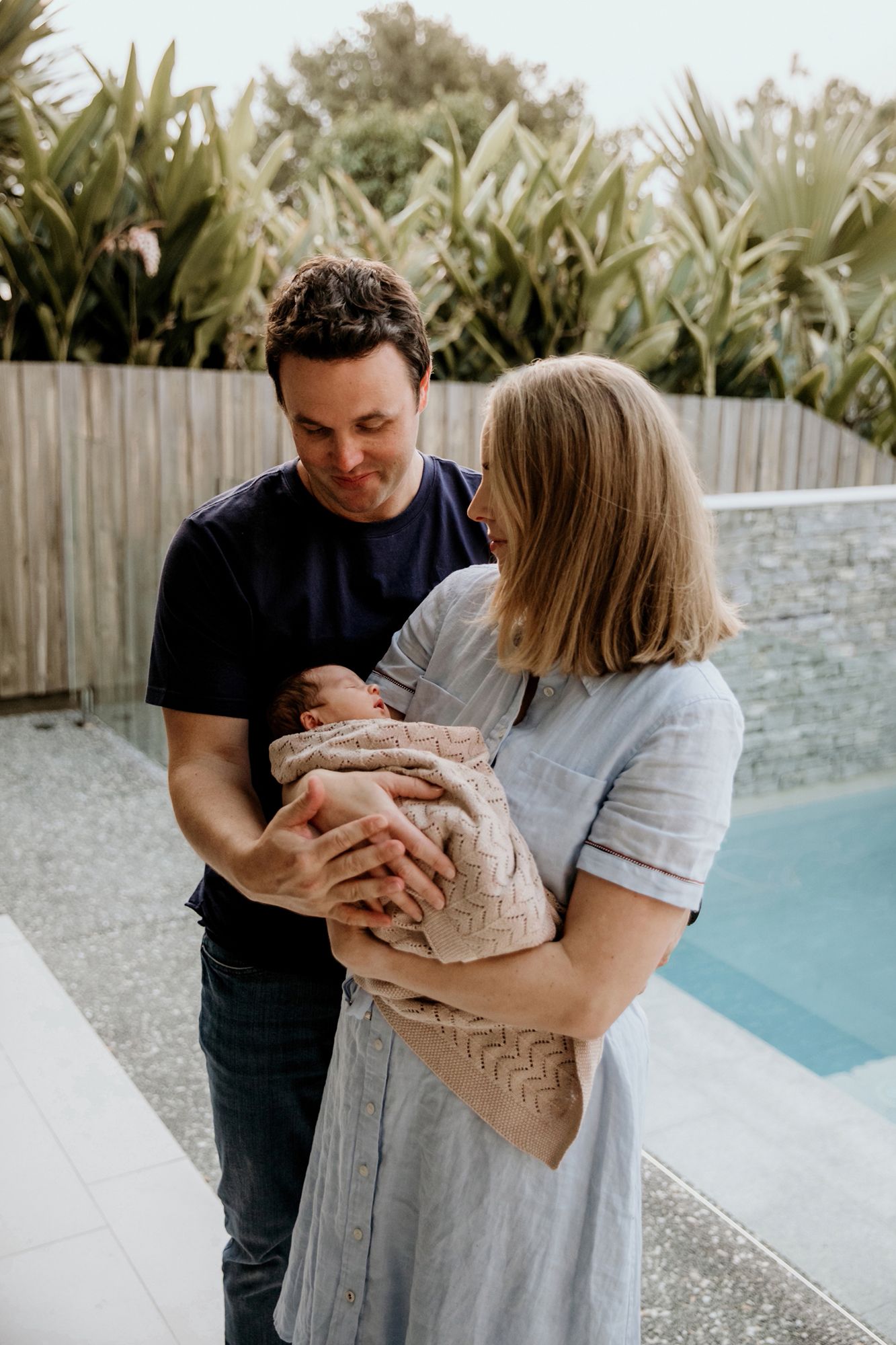 In-home newborn photography at the Redlands area Wellington Point Ormiston outdoors by swimming pool with Mum and Dad.