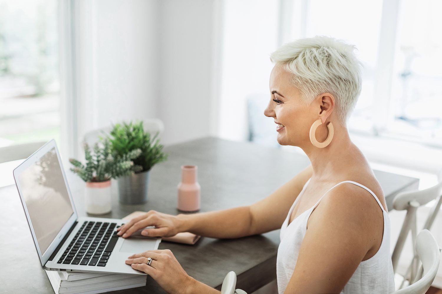 Raby Bay business photographer photographs business woman working on laptop in bright modern office with natural lighting.