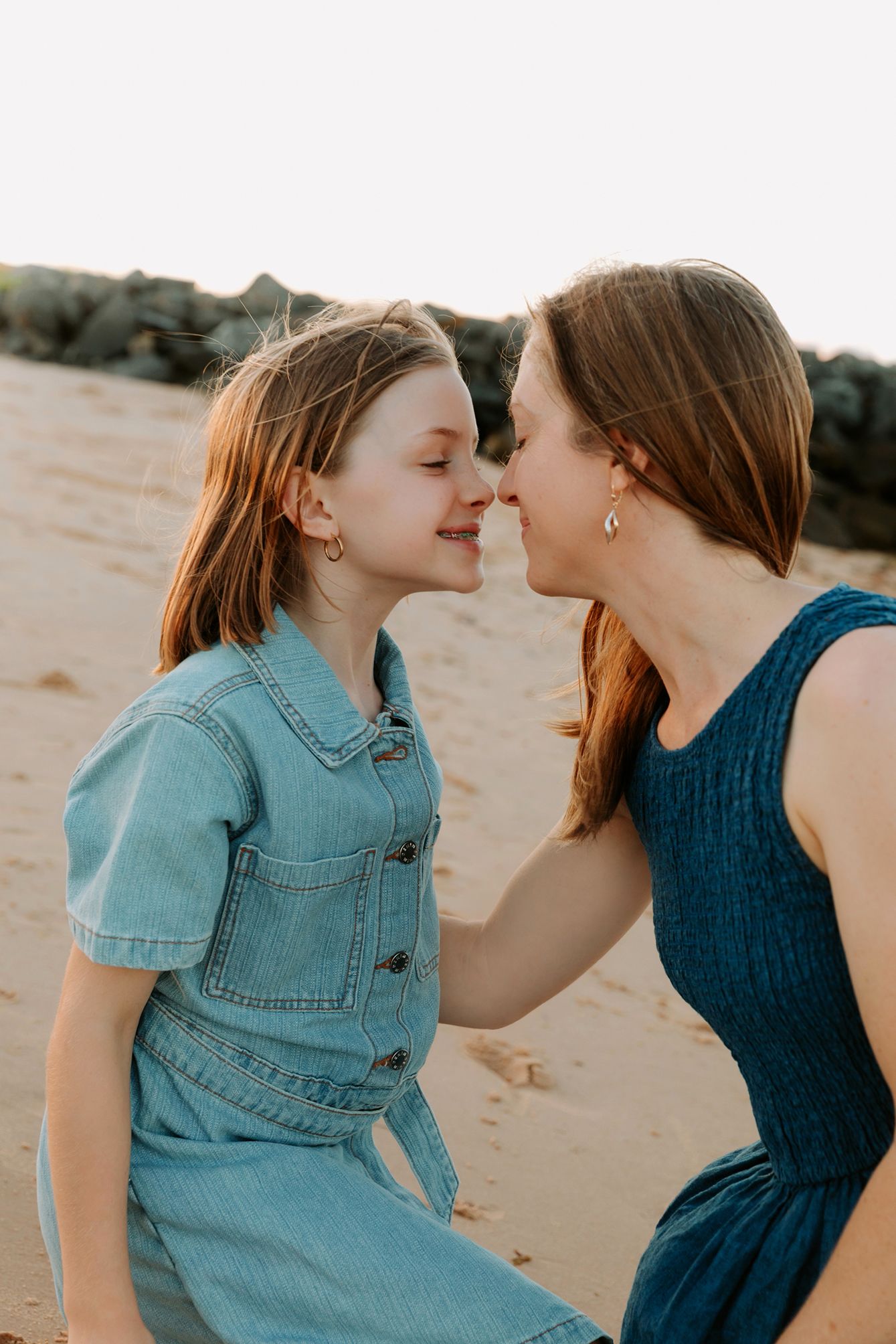 Brisbane family photography on bayside beach illustrating warm connection between mother and daughter.