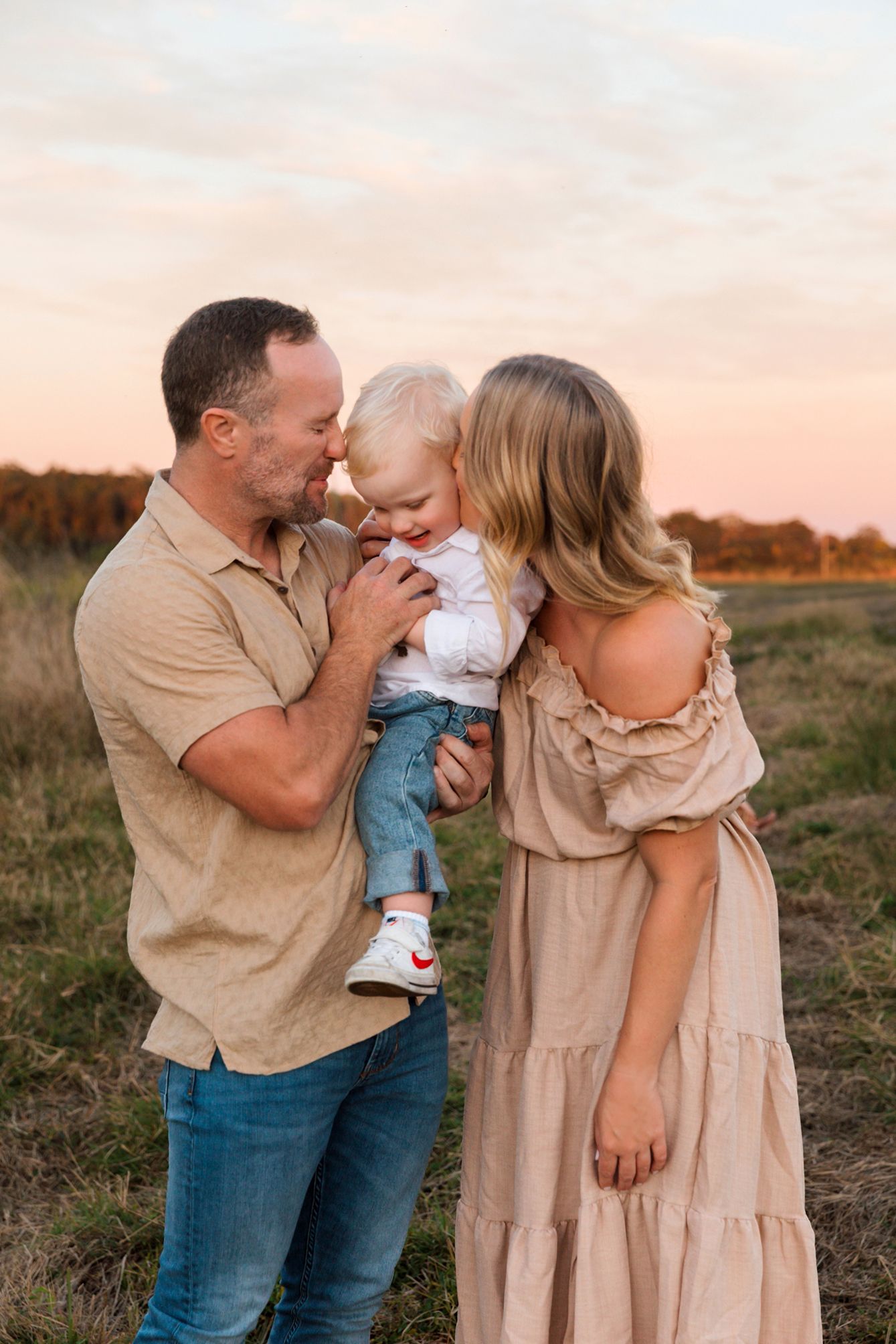 Intimate family photography captured against pink sunset sky at grassy field location of Mt Cotton Queensland.