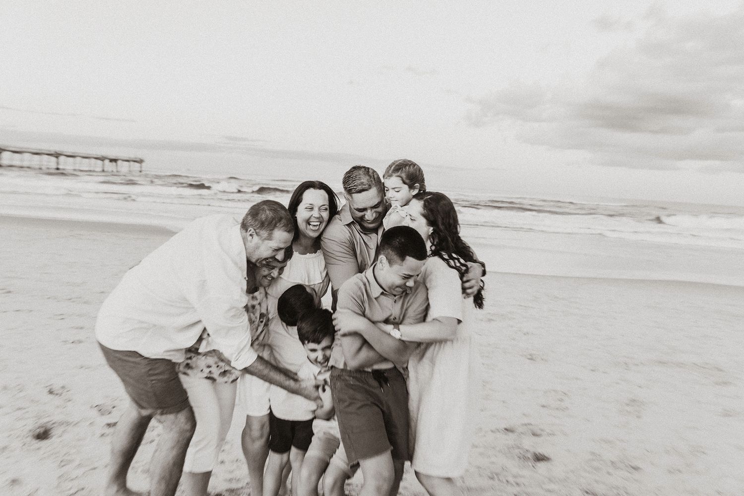 Candid photograph of extended family playing on a Gold Coast sandy beach.