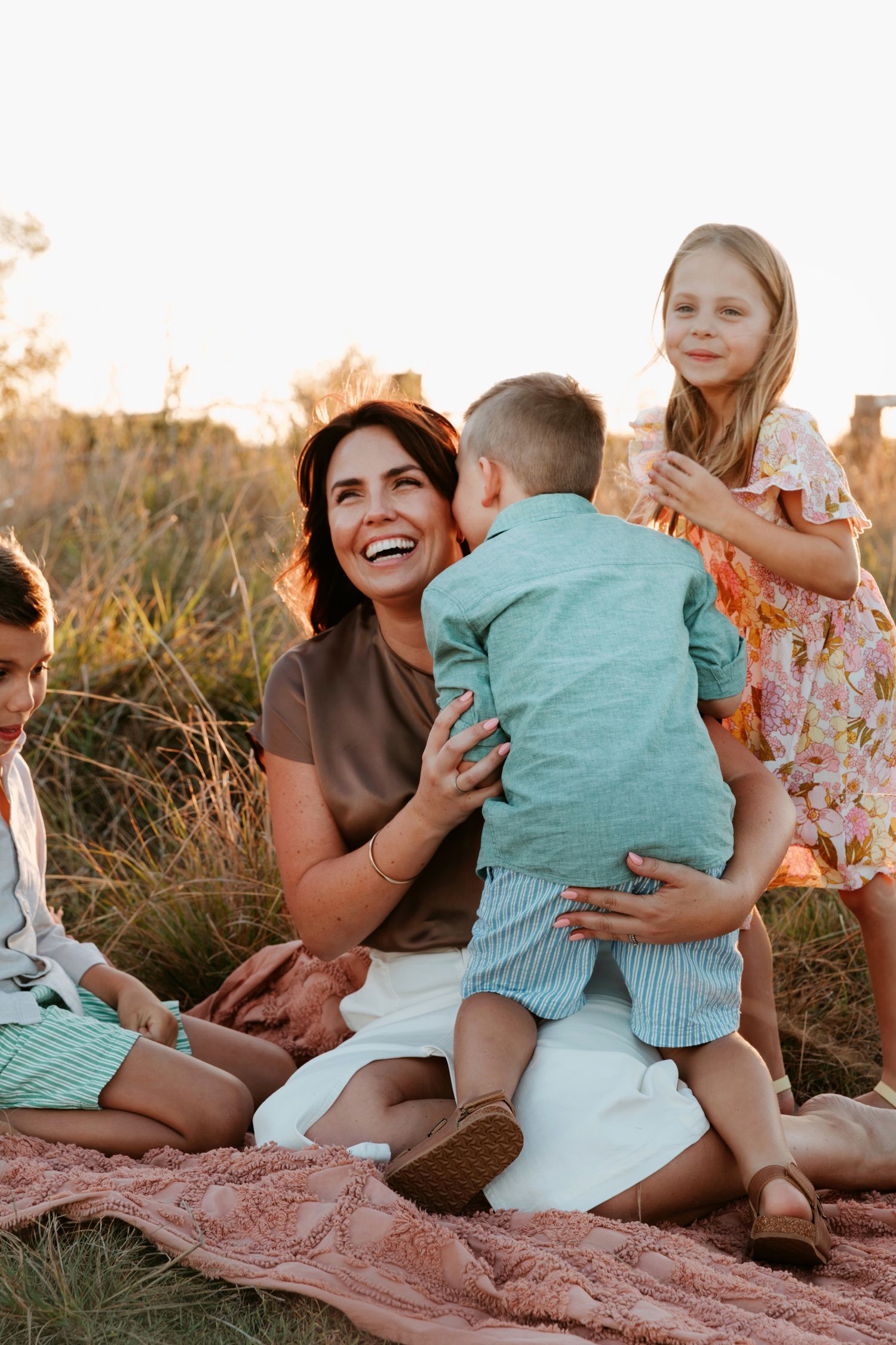 Mt Cotton photographer illustrating family connection and love in grassy field.