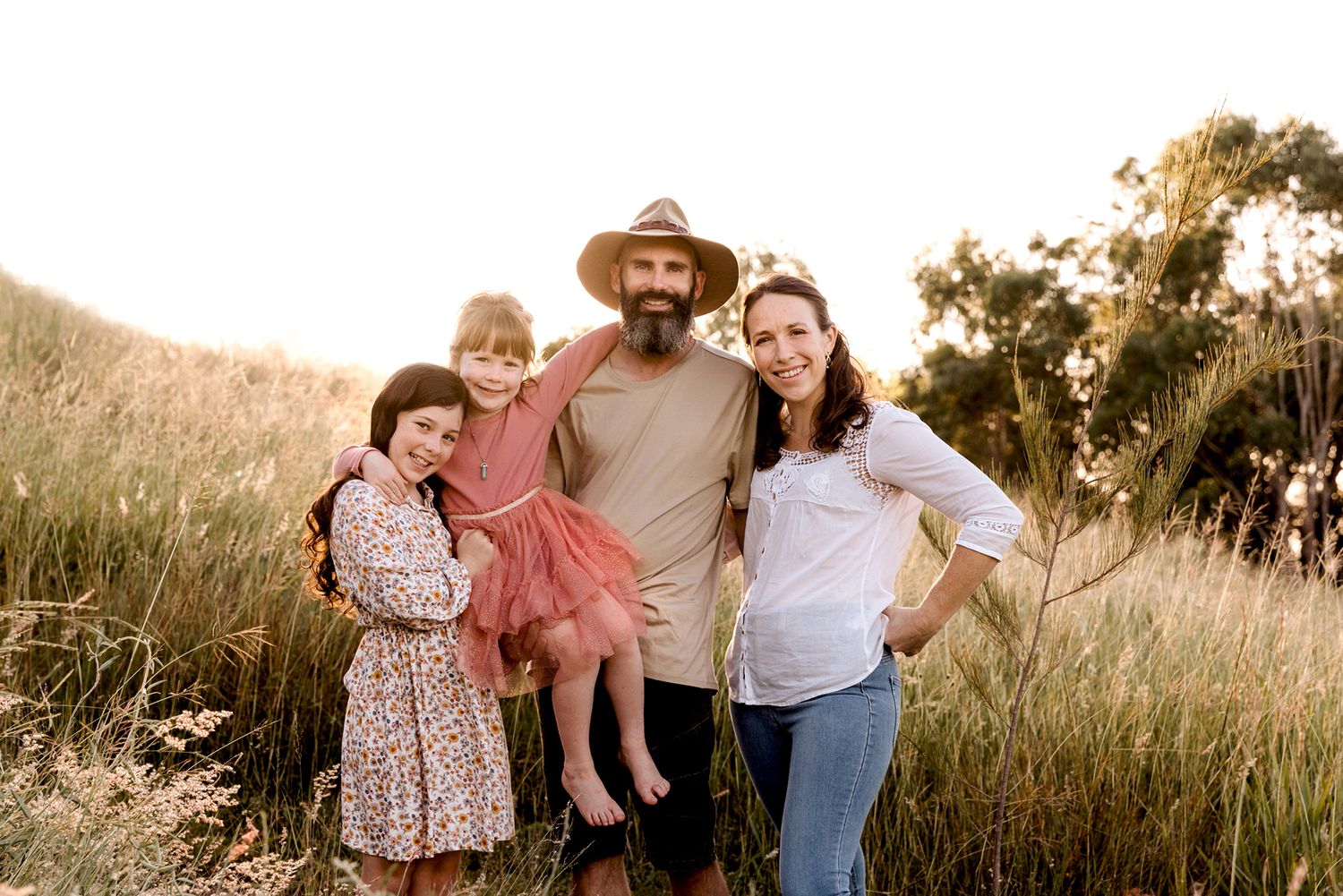 Natural family portraits captured in golden sunlight among tall grass in the Redlands, Queensland.