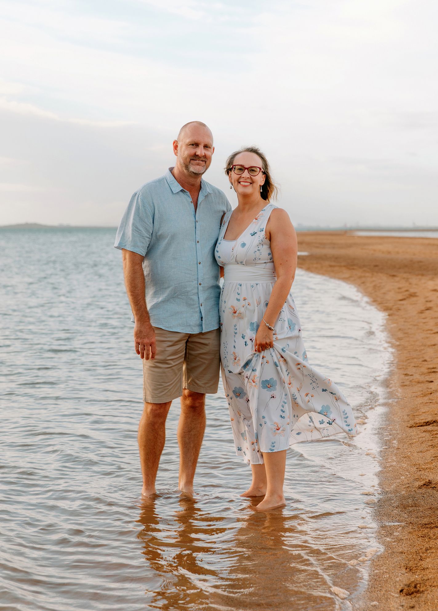 Couple wades in shallow water at Wellington Point reserve Brisbane for family photo shoot.