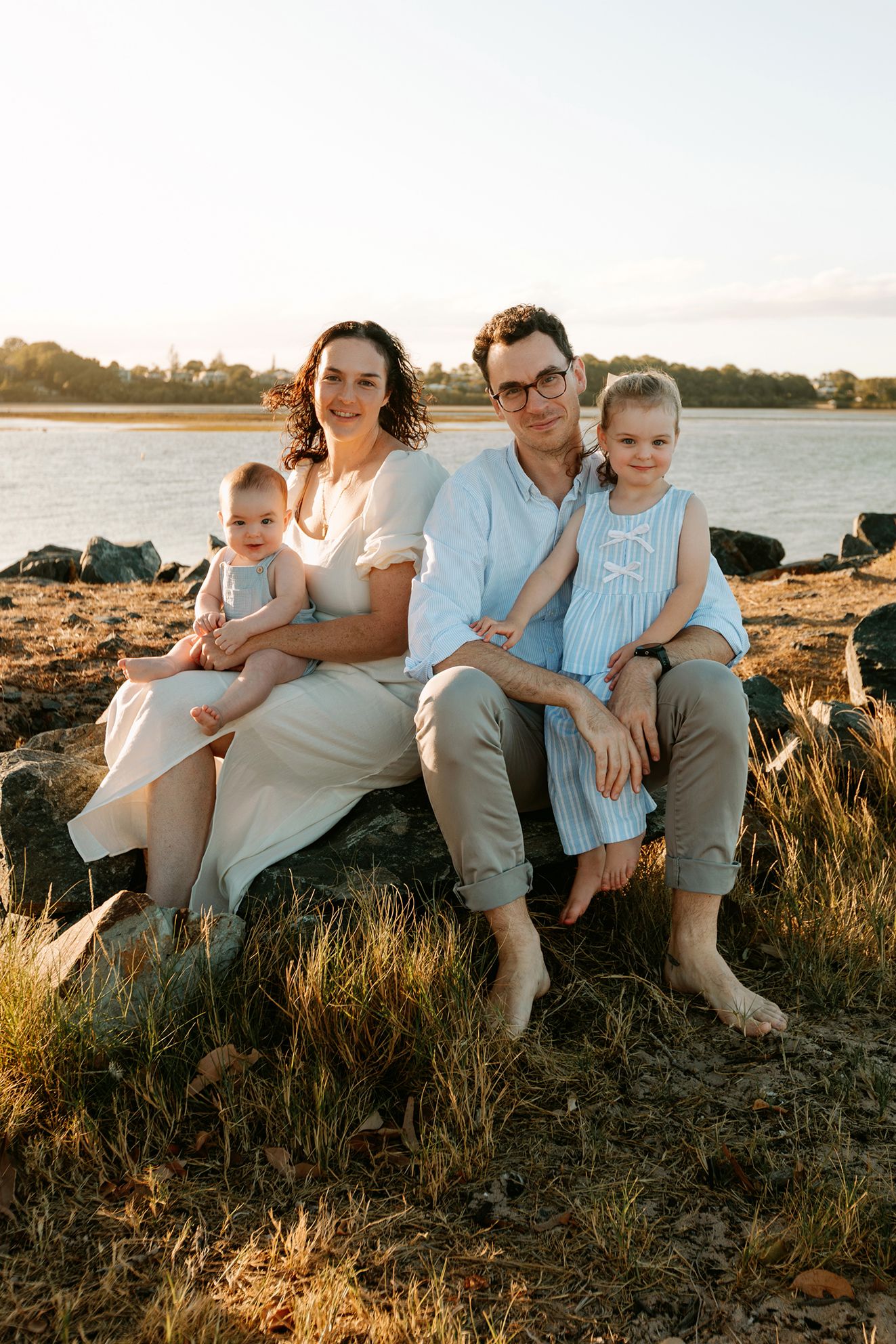 Brisbane family photography at grassy bayside shore during golden hour.