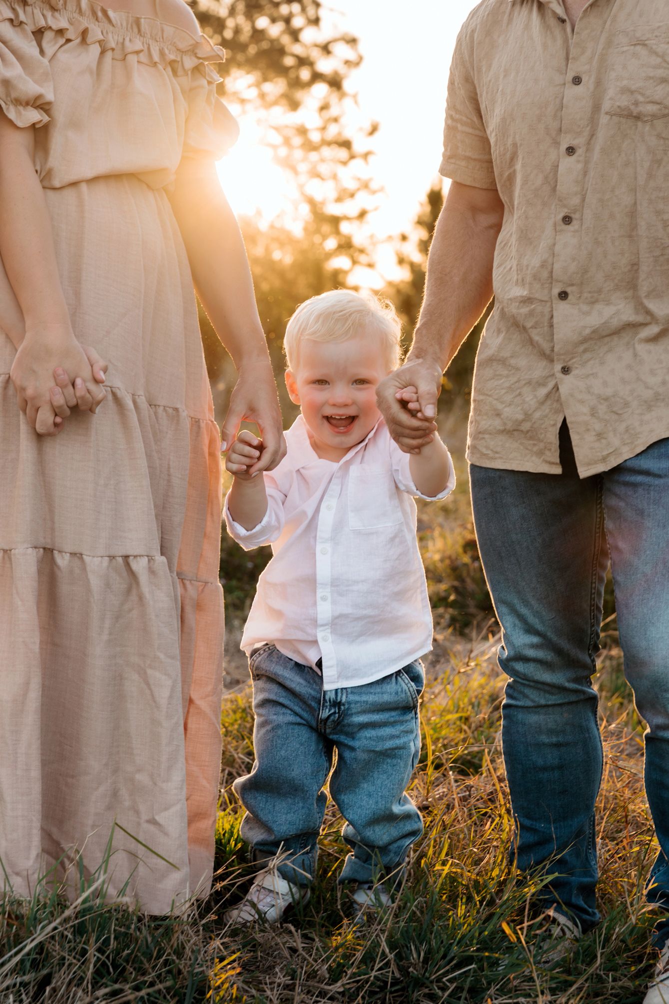 Sunset family photography illustrating a boys love for his mother and father holding hands at Brisbane Queensland.
