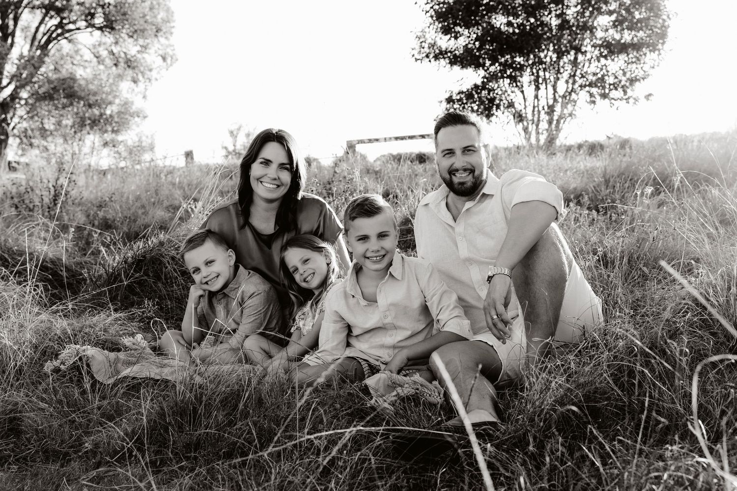 Brisbane photographer takes photo in grassy field at Mt Cotton of family of five.