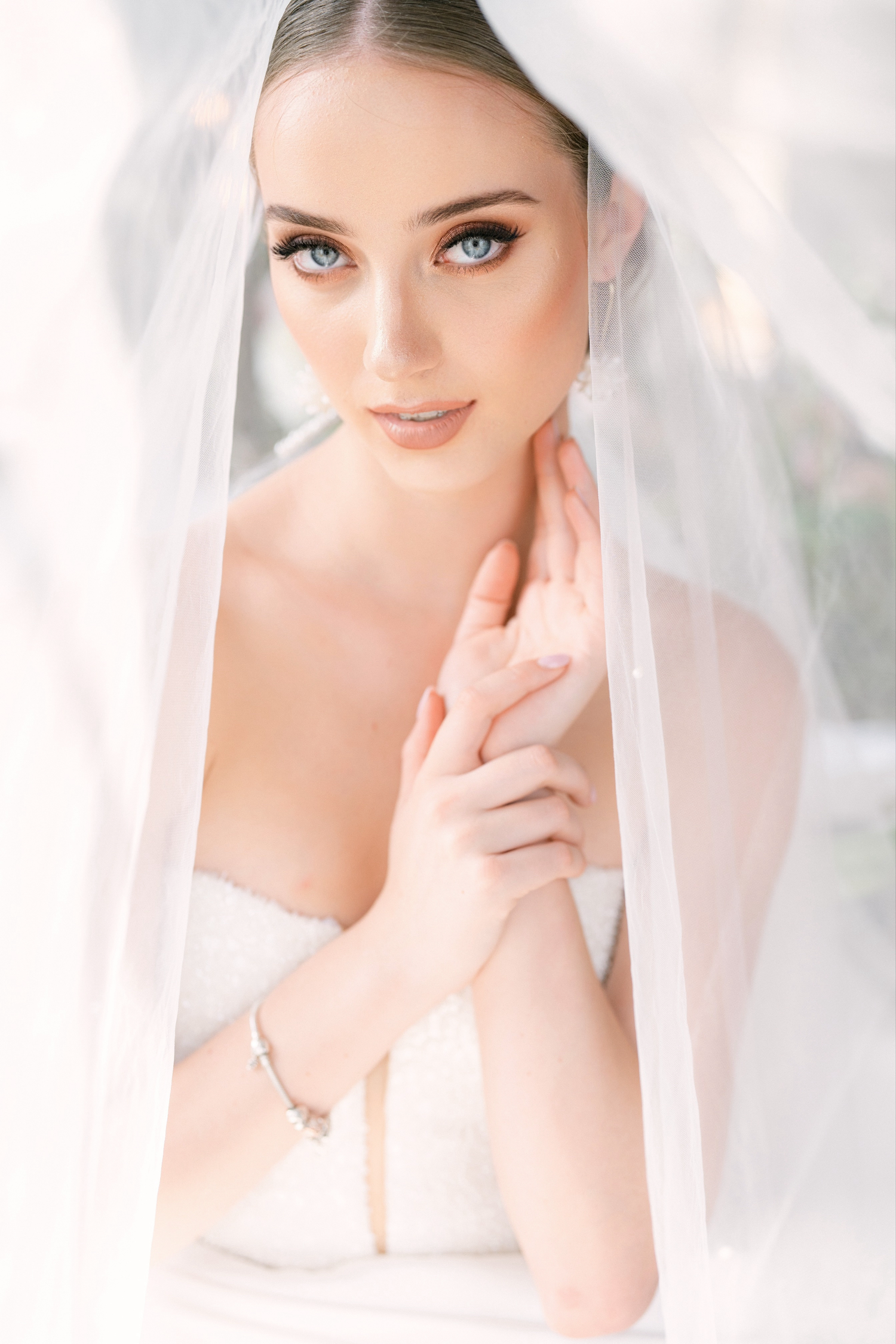 Portrait series of a bride wearing white veil and natural bridal makeup looking ethereal and elegant.