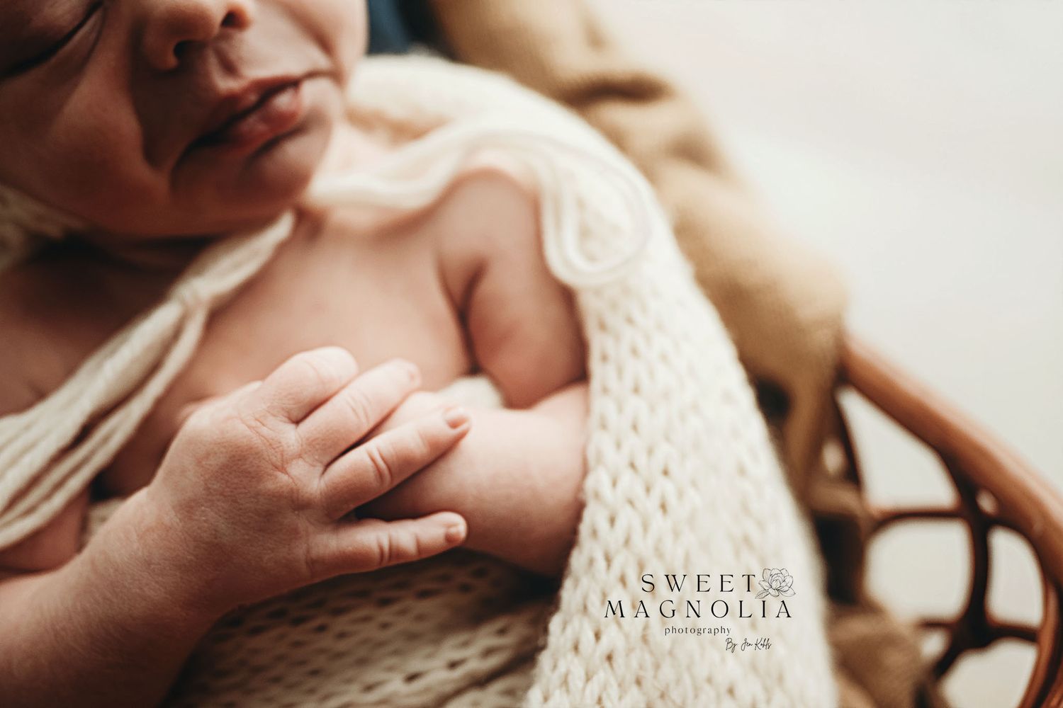 Close-up of tiny hand grasping knit fabric in soft natural light.