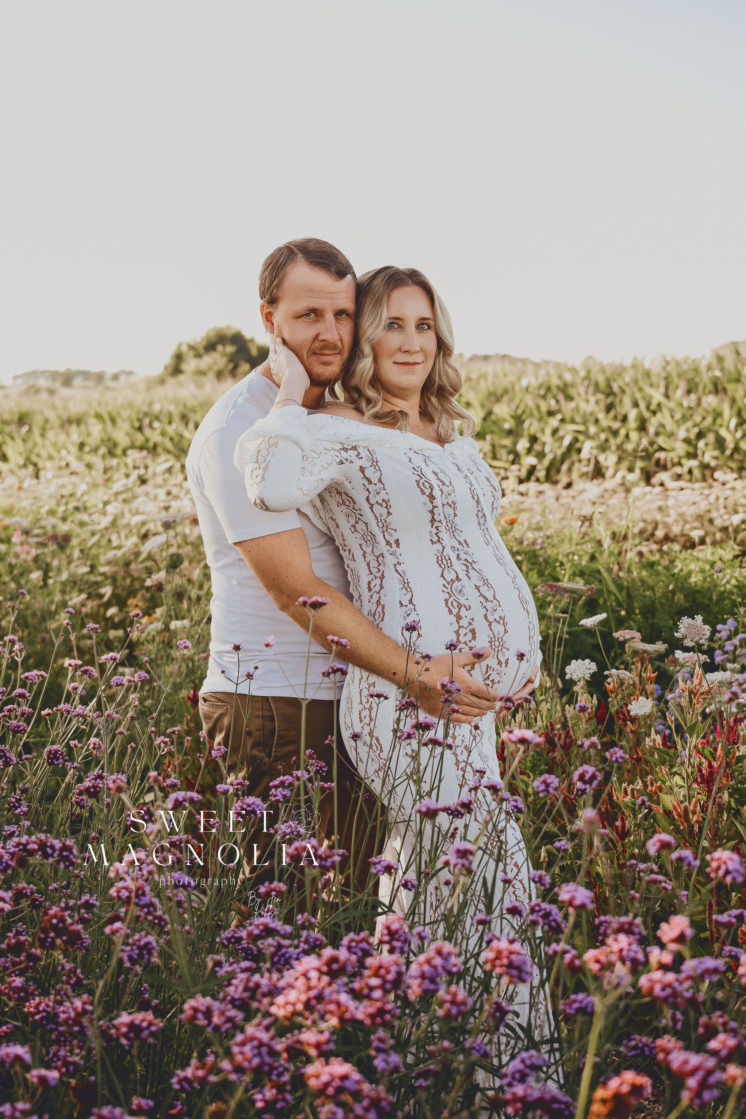 Couple posing in a wildflower field during golden hour.