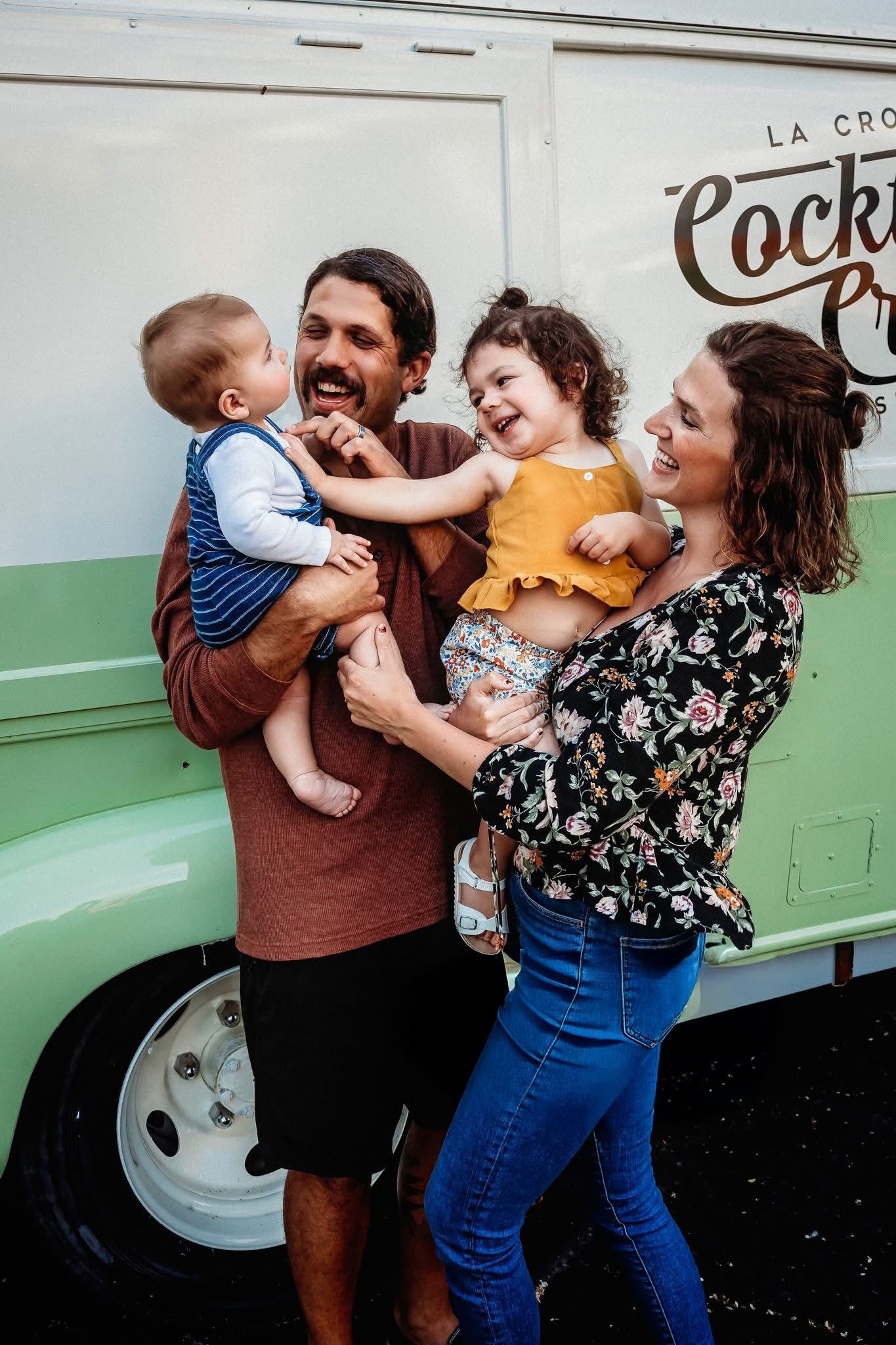 A joyful family moment shared in front of a food truck with laughing children.
