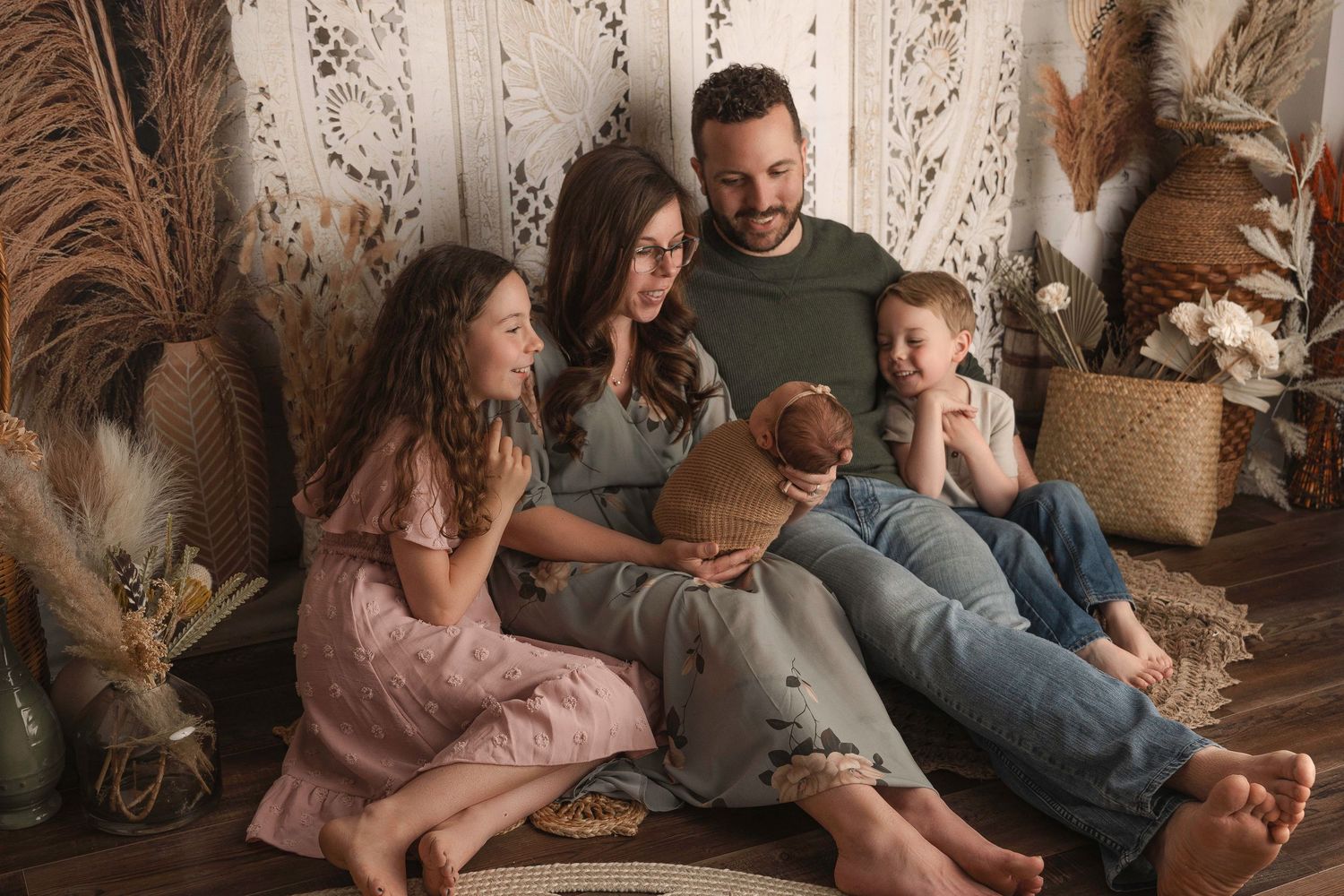 Cozy family lifestyle session with bohemian decor and warm neutral tones.