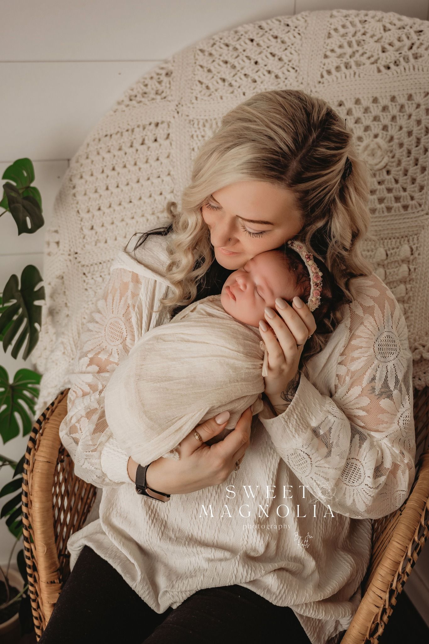 Intimate lifestyle portrait in a wicker chair with macrame wall hanging and soft natural lighting.
