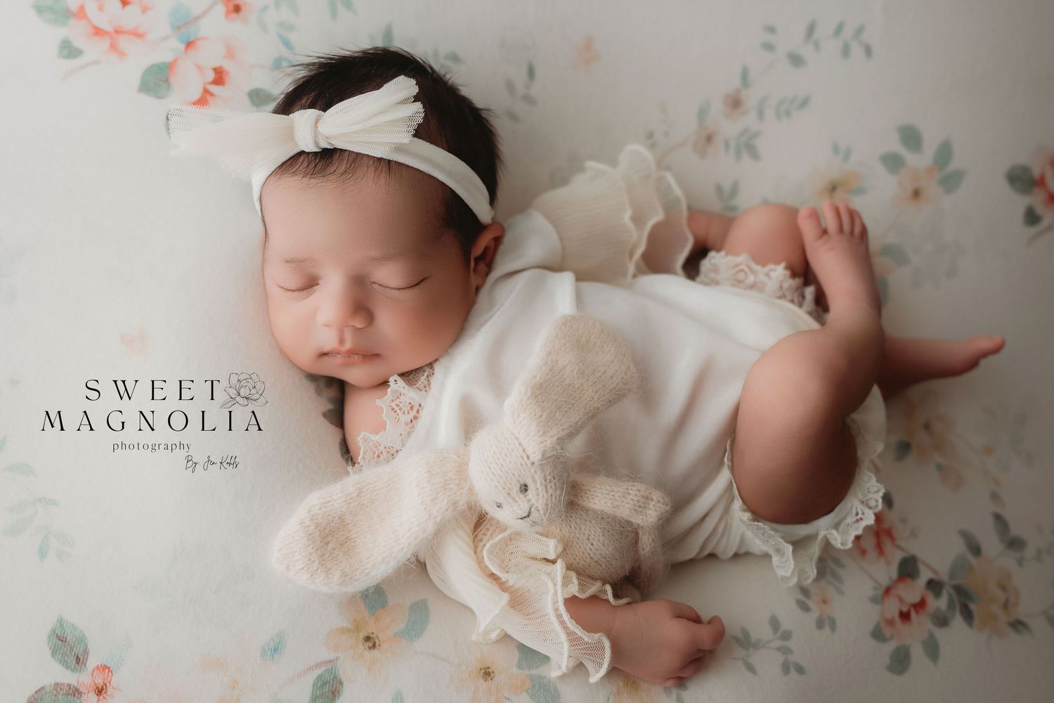 Sweet newborn photography with vintage floral wallpaper and white dress details.