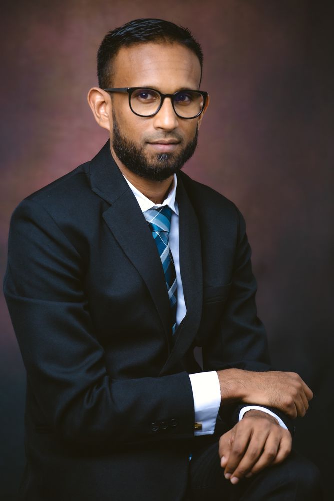 Professional studio portrait series showing a person in a dark suit and blue tie against a moody brown background.