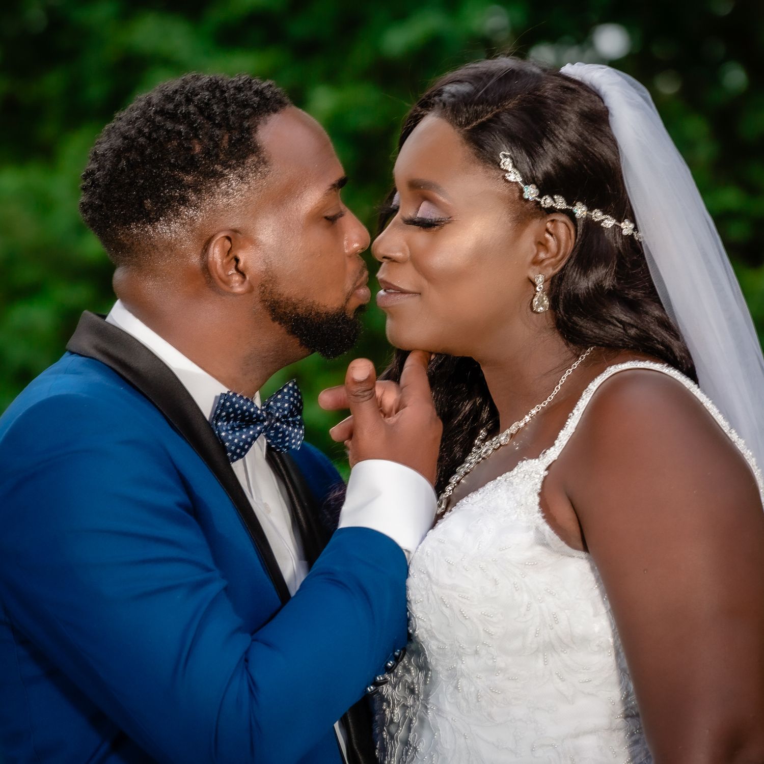 Intimate portrait of bride and groom sharing a romantic moment in a garden setting.