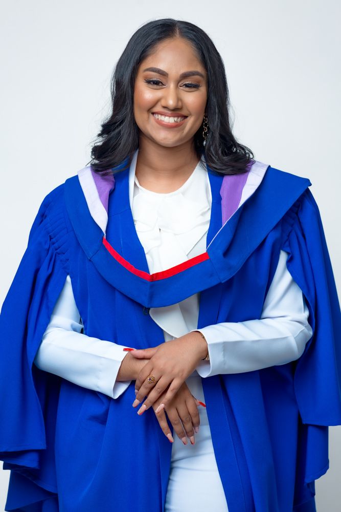 A series of four photos showing someone in a blue graduation gown and white top smiling and posing with crossed arms.