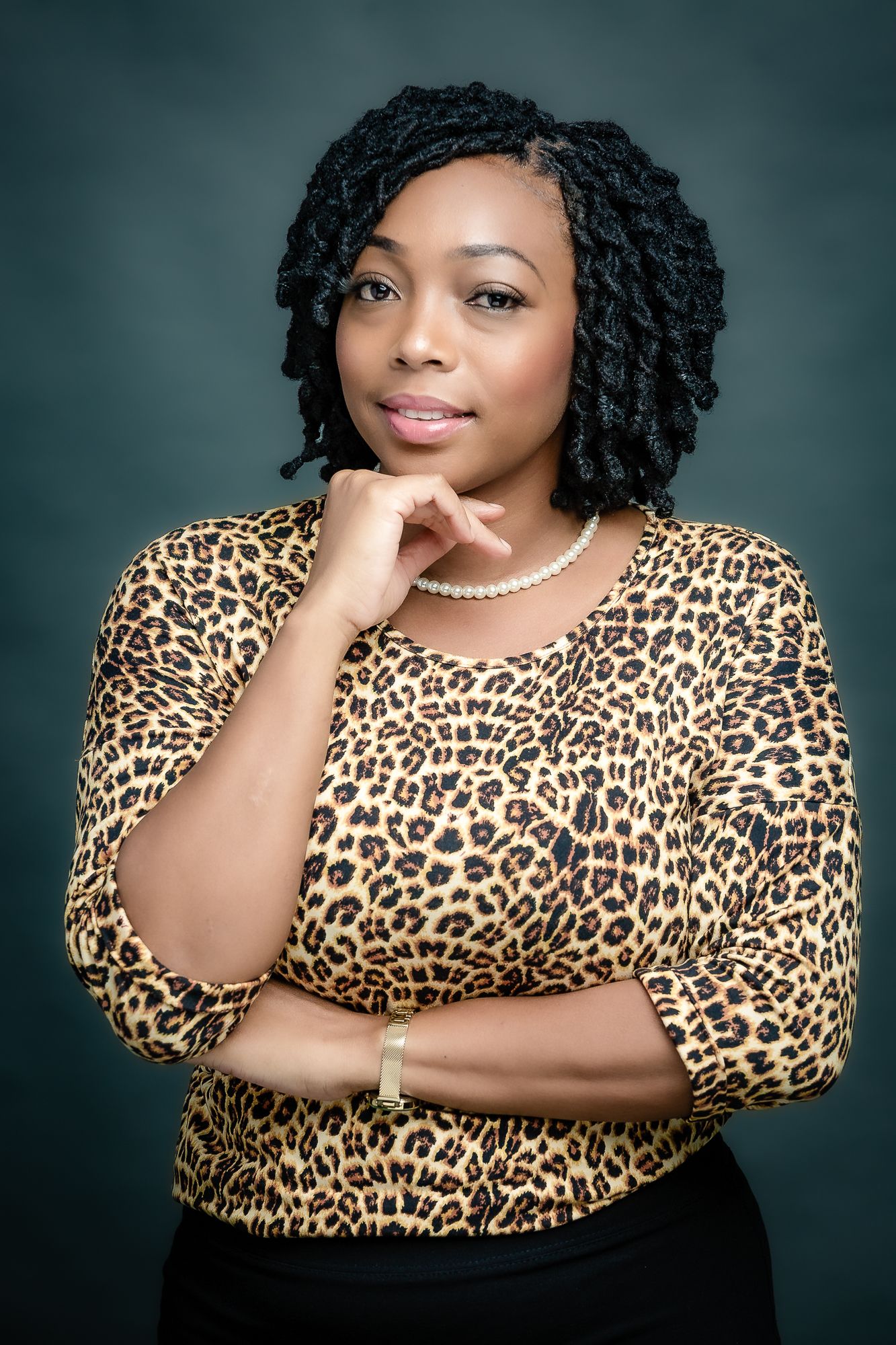 Elegant studio photo with pearls and leopard print top in professional pose.