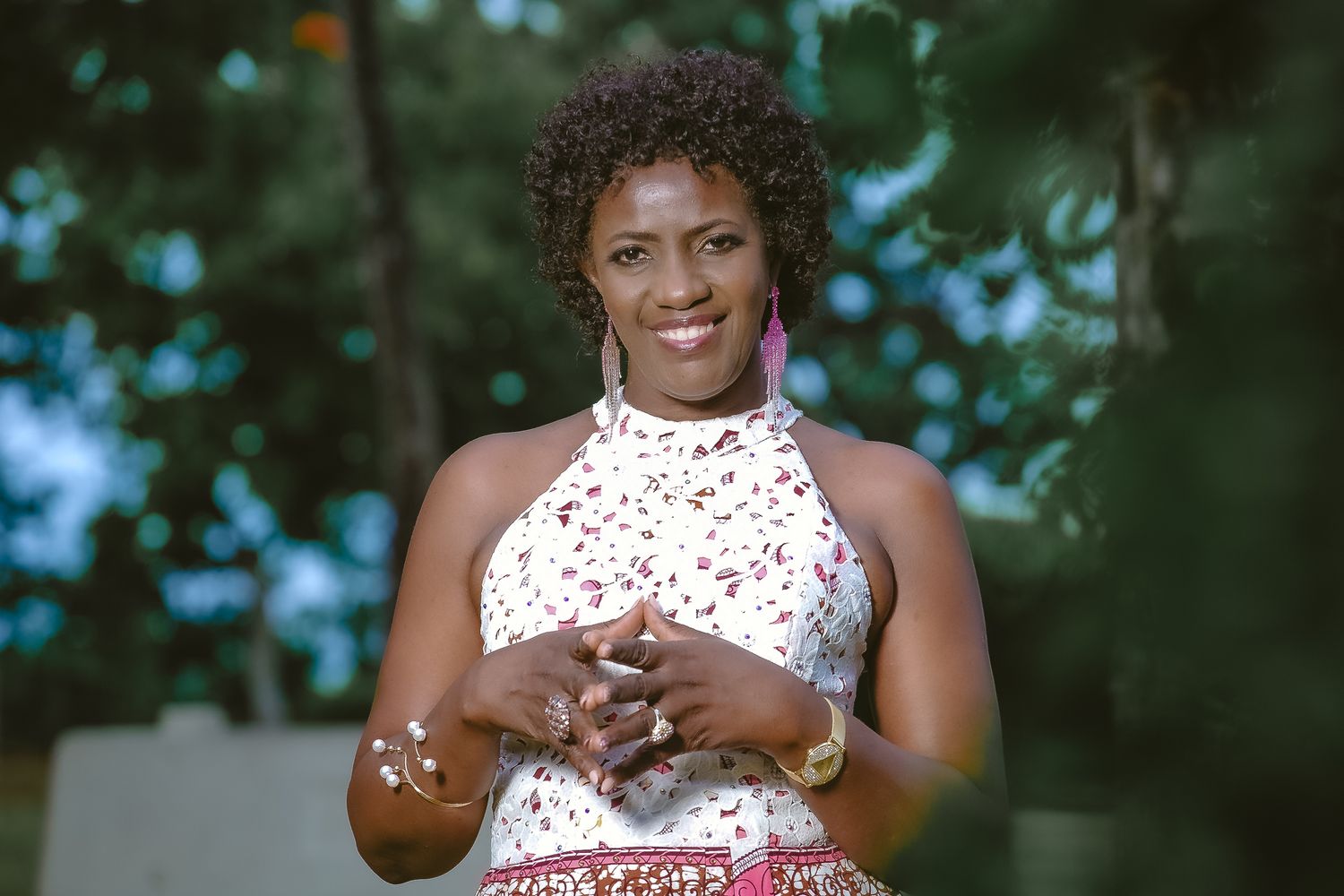 Woman in white floral halter top and patterned skirt outdoors.