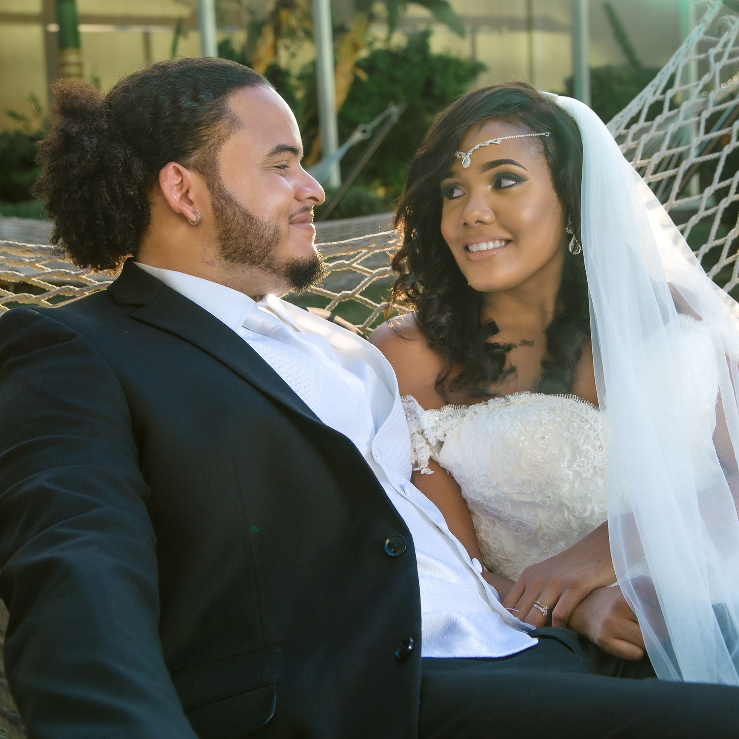 An intimate wedding portrait shows a couple sharing a tender moment outdoors.